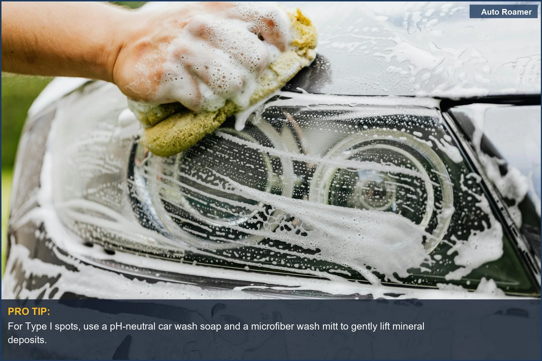 Detailing a car headlight with soap and sponge to remove early-stage water spots on paint.