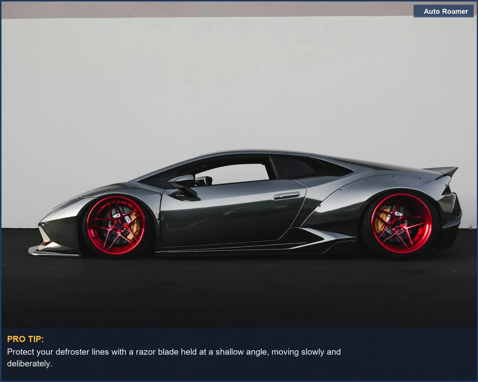 Man carefully removing old window tint from a car's rear window without damaging defroster lines.
