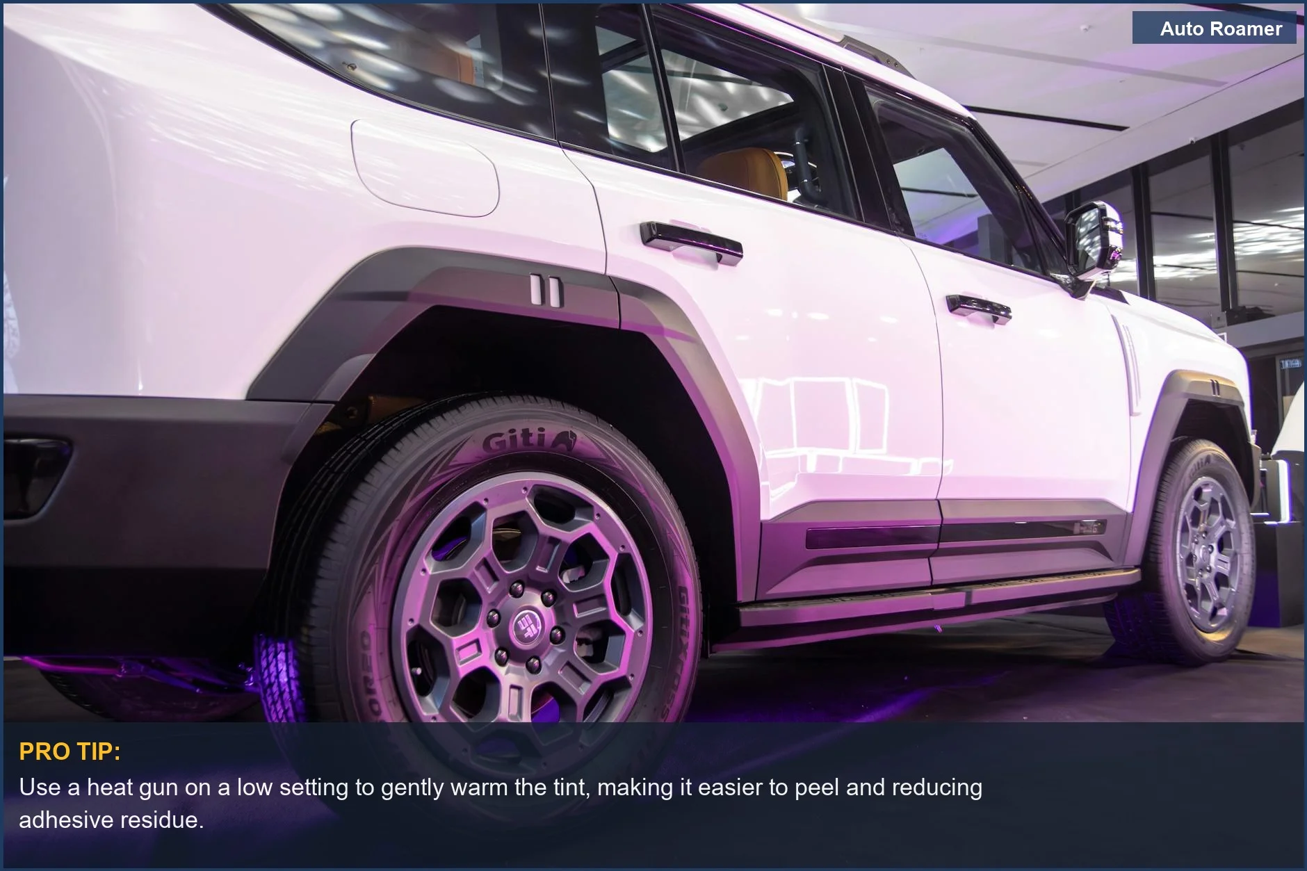 Close-up of a car's purple tinted window revealing bubbles and peeling, a common sign it needs removal.