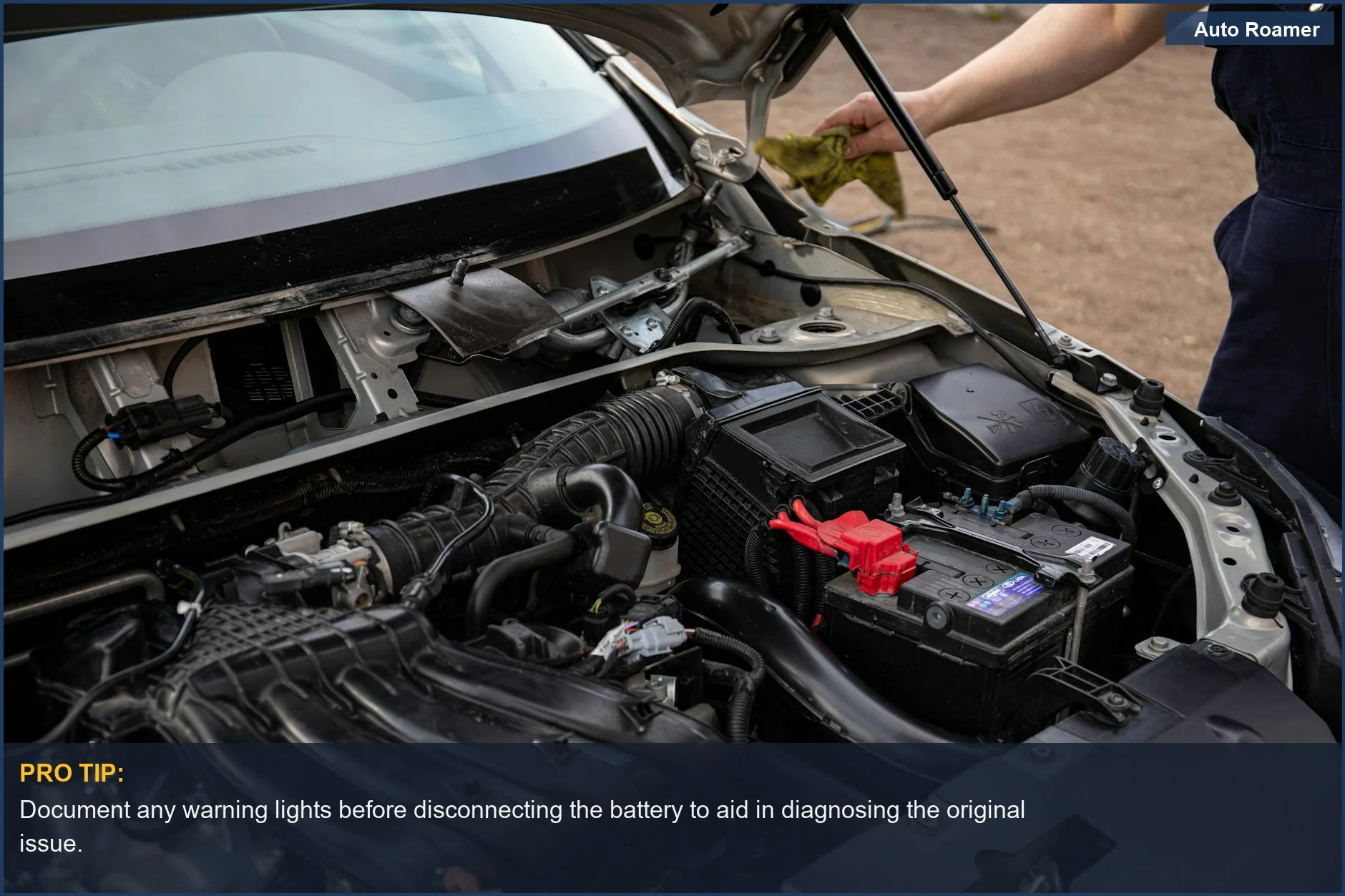 Mechanic inspecting a car's engine bay and battery during routine car maintenance checks.