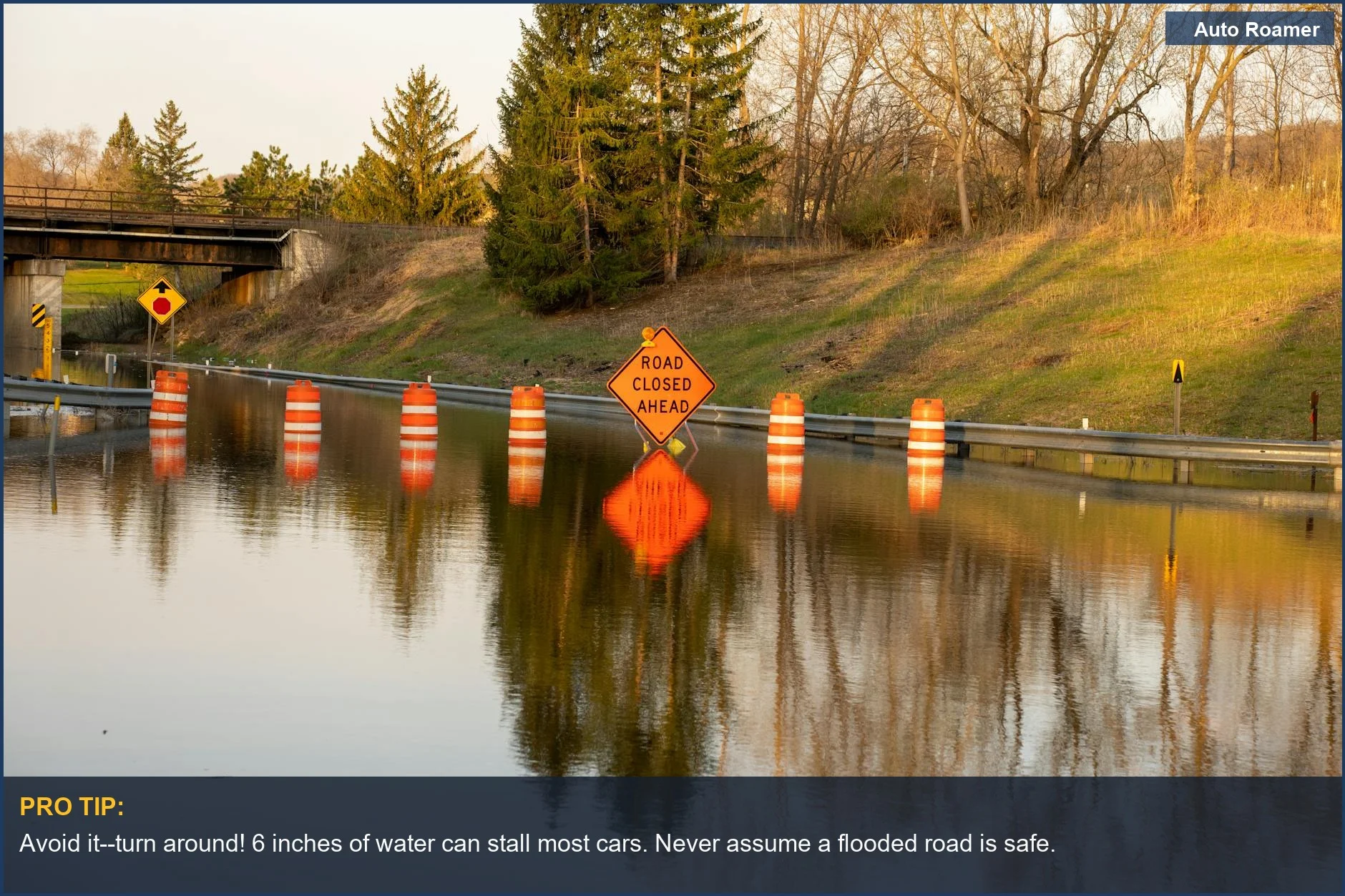 Shows a flooded road with 'Road Closed Ahead' signs, emphasizing the need to safely drive through standing water.