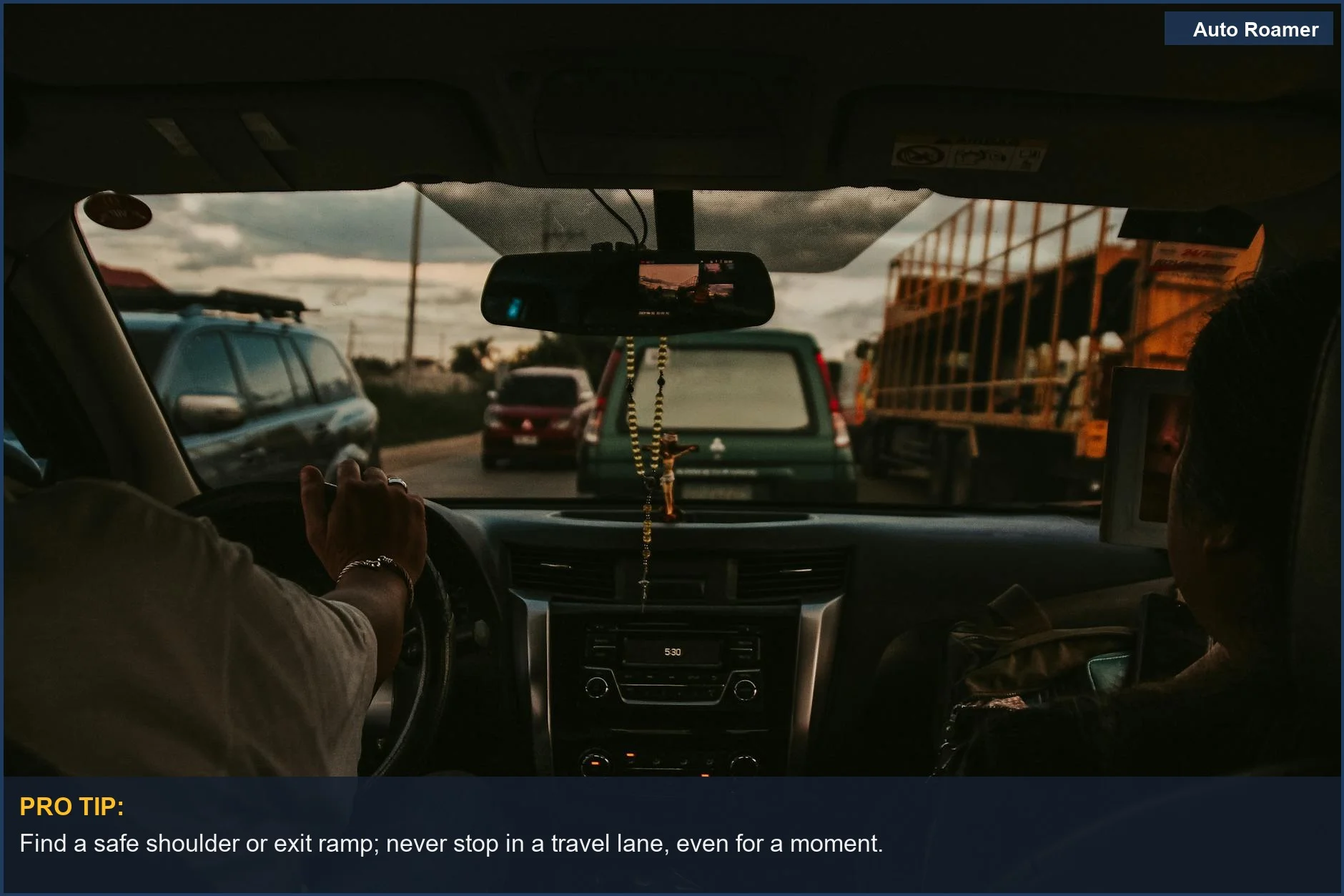 View from inside a car stuck in traffic on a busy Philippine road at sunset, demonstrating how to pull over.