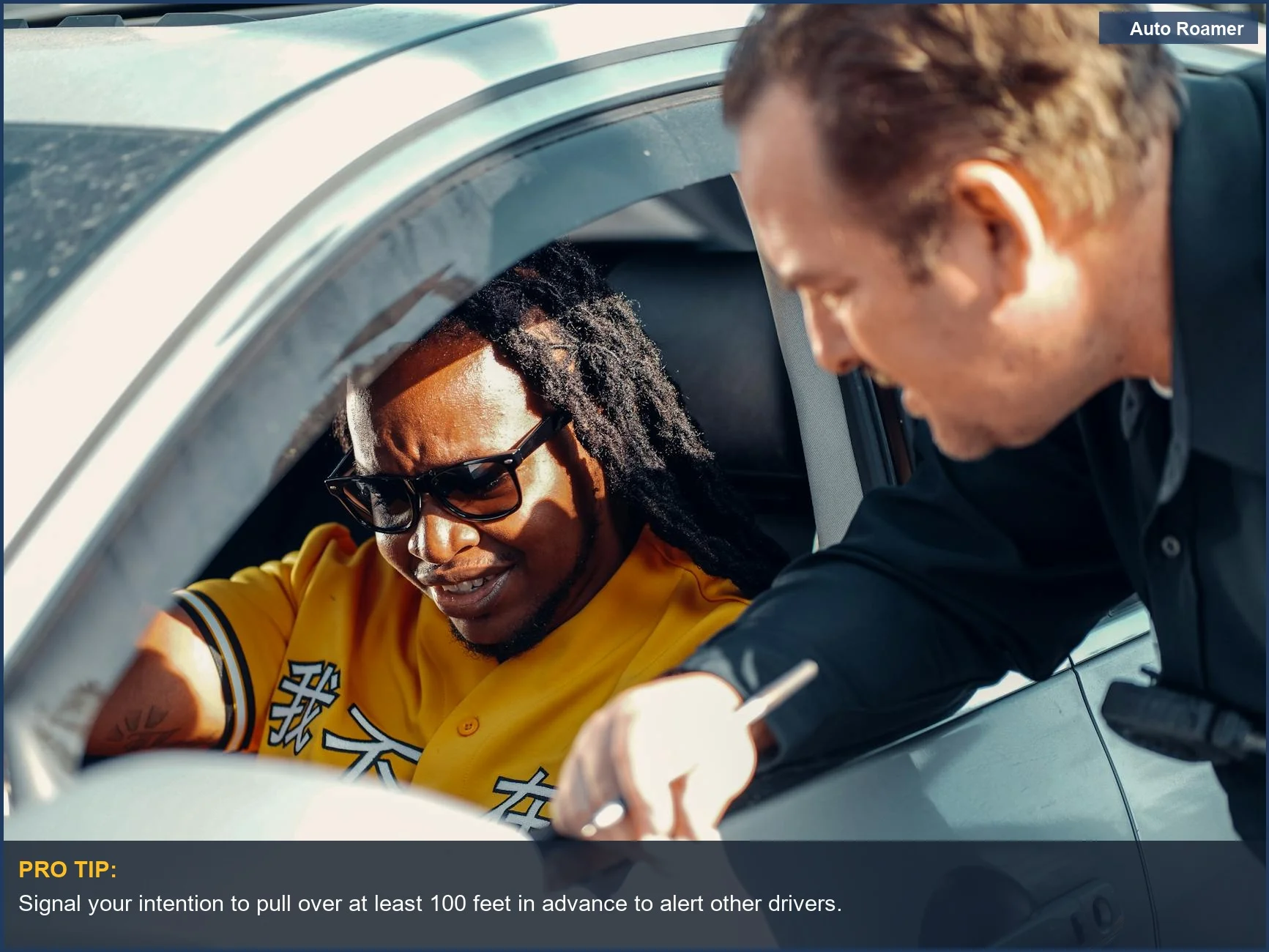 Police officer assisting a driver during a traffic stop on the highway.