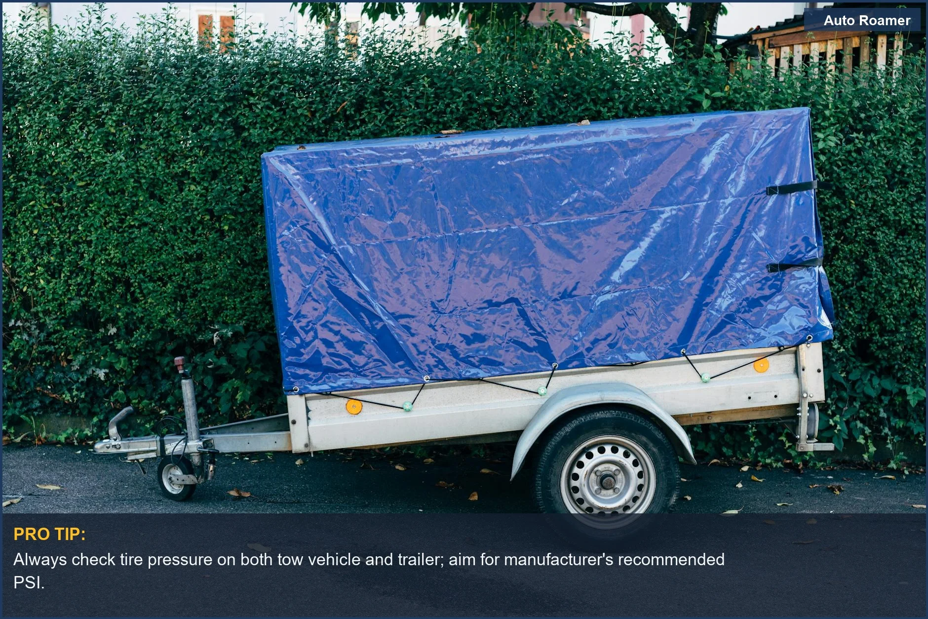 Blue tarpaulin-covered trailer parked roadside, emphasizing pre-drive checks for towing safety.