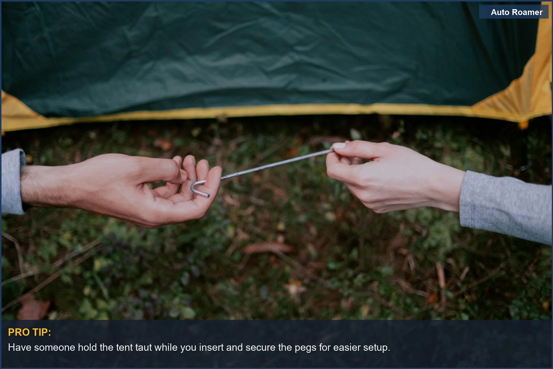 Two people working together to set up a tent with metal pegs in an outdoor camping area.