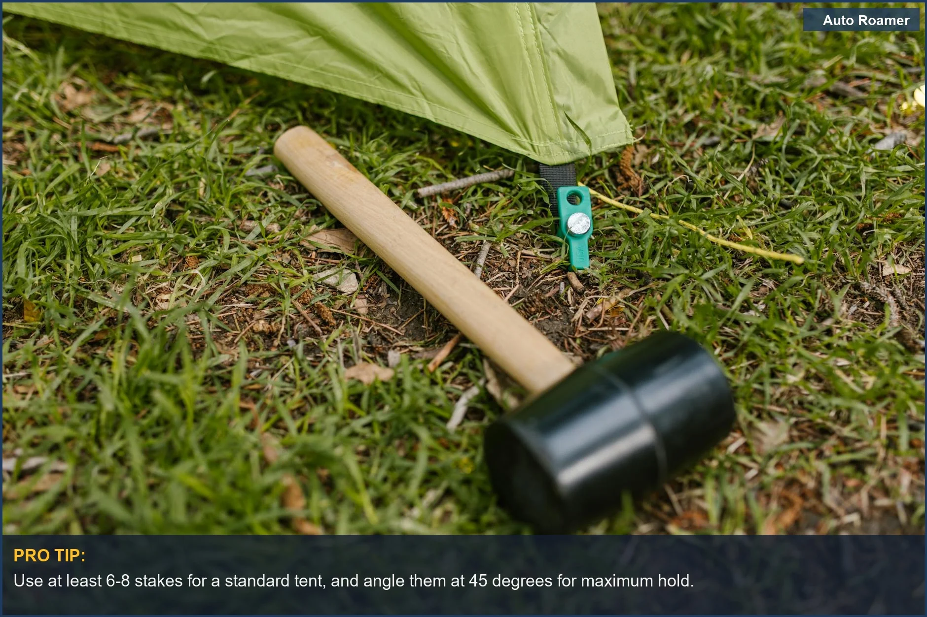 Close-up of a rubber mallet and tent pegs securing a green tent on grass, essential for campsite setup.