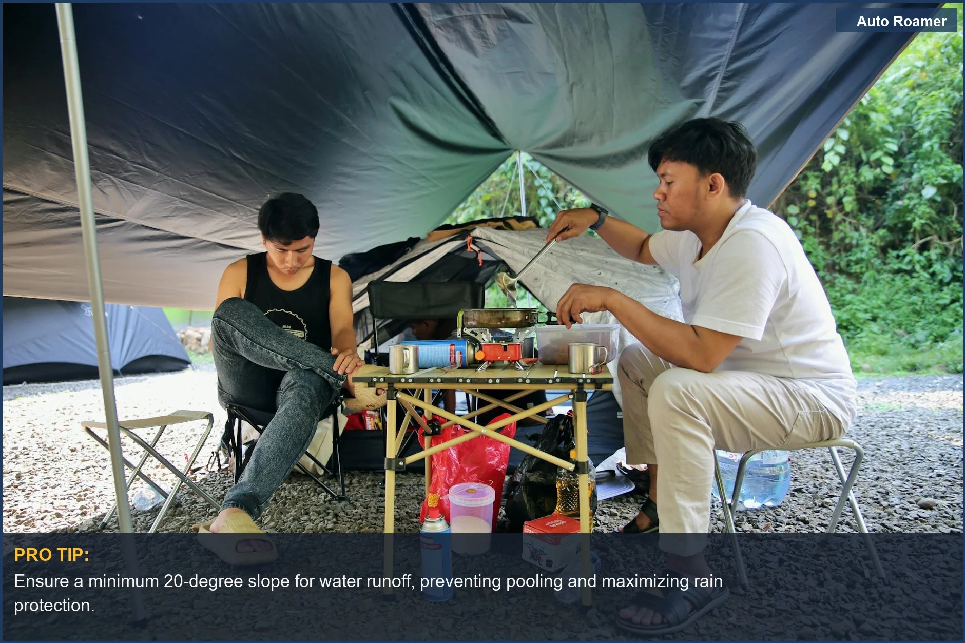 Campers preparing food under a well-pitched tarp, demonstrating effective rain protection for car camping shelter.