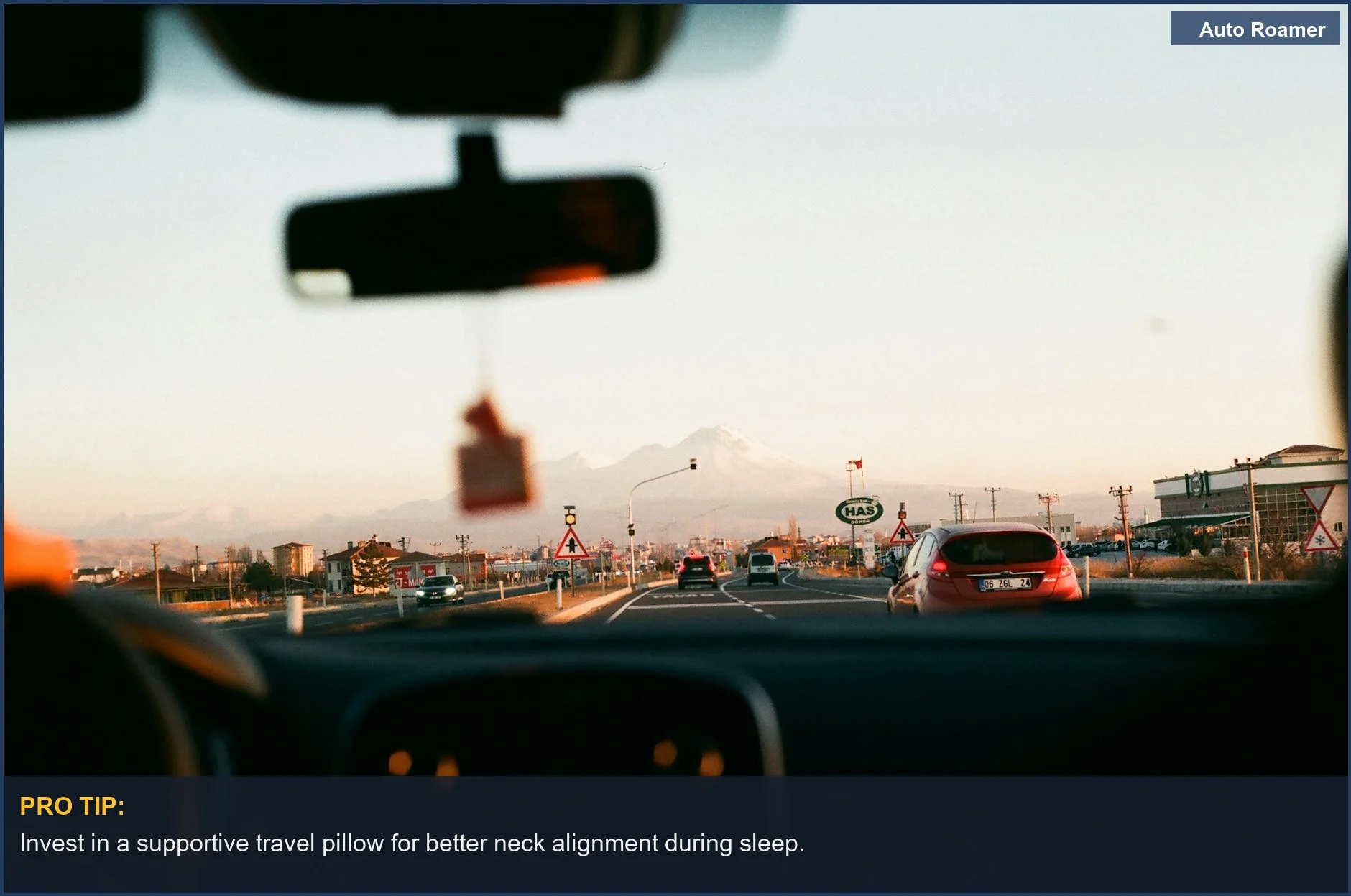 Interior view of a car driving towards mountains at sunset, perfect for road trip comfort.