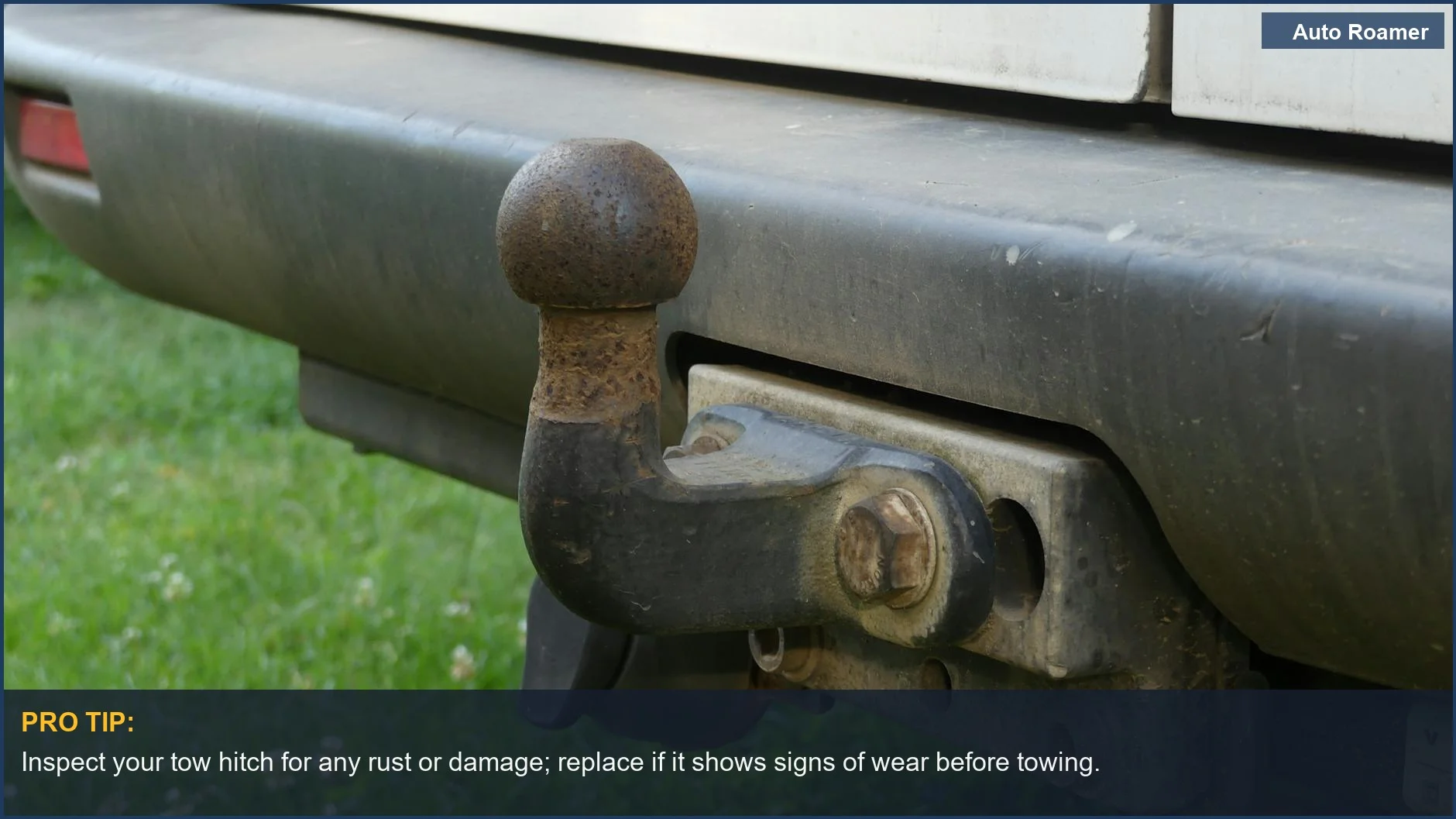 Close-up of a rusty tow hitch on a vehicle's rear bumper for towing without a tow truck.