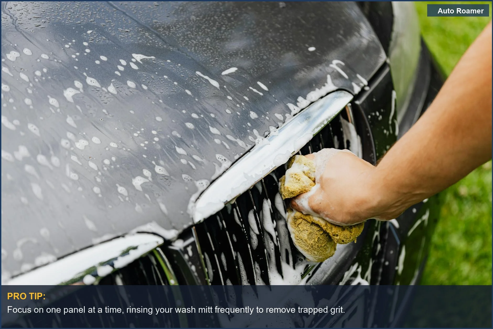 Close-up of hand gently washing car grille, preventing car wash swirl marks.