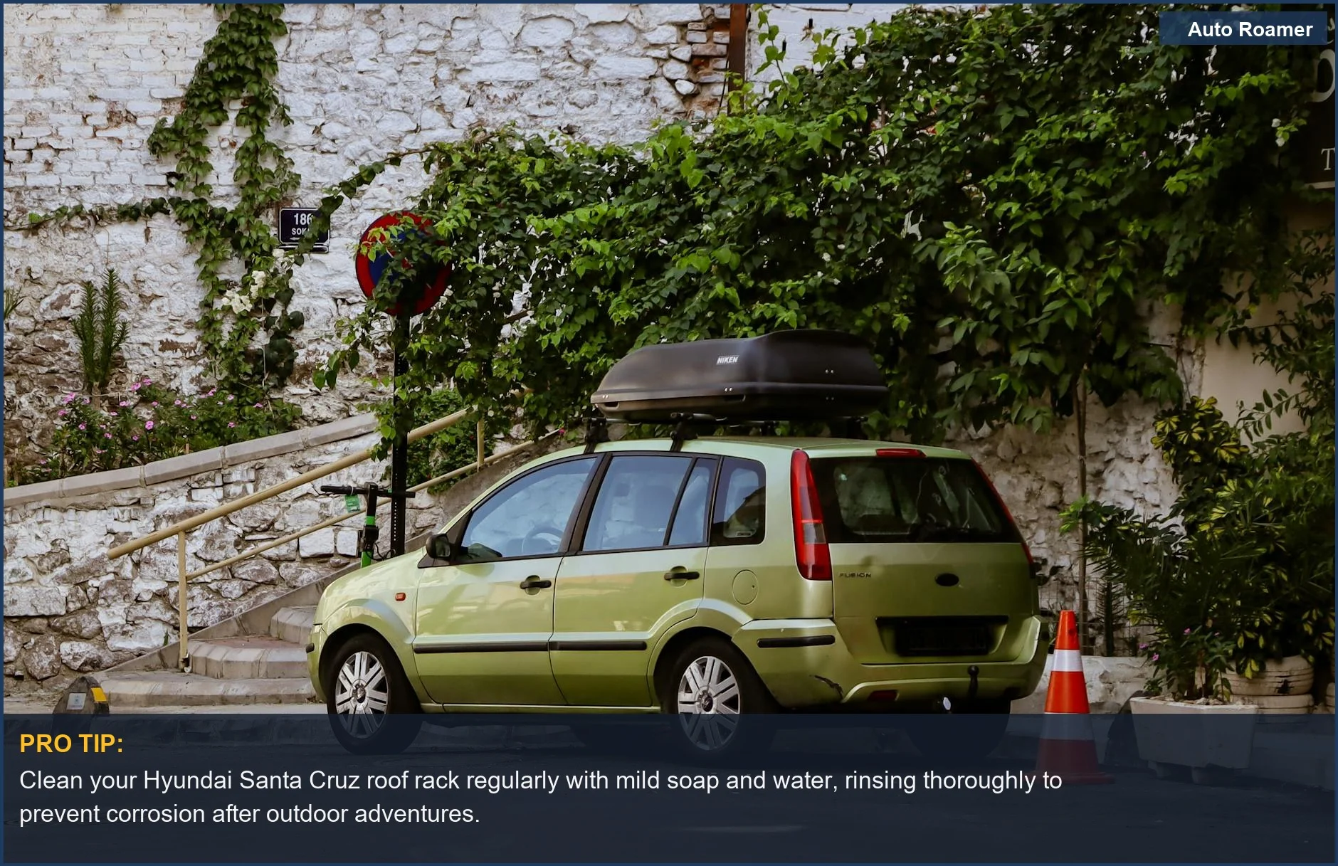 Green car with a rooftop box on a leafy street, demonstrating Santa Cruz roof rack maintenance.