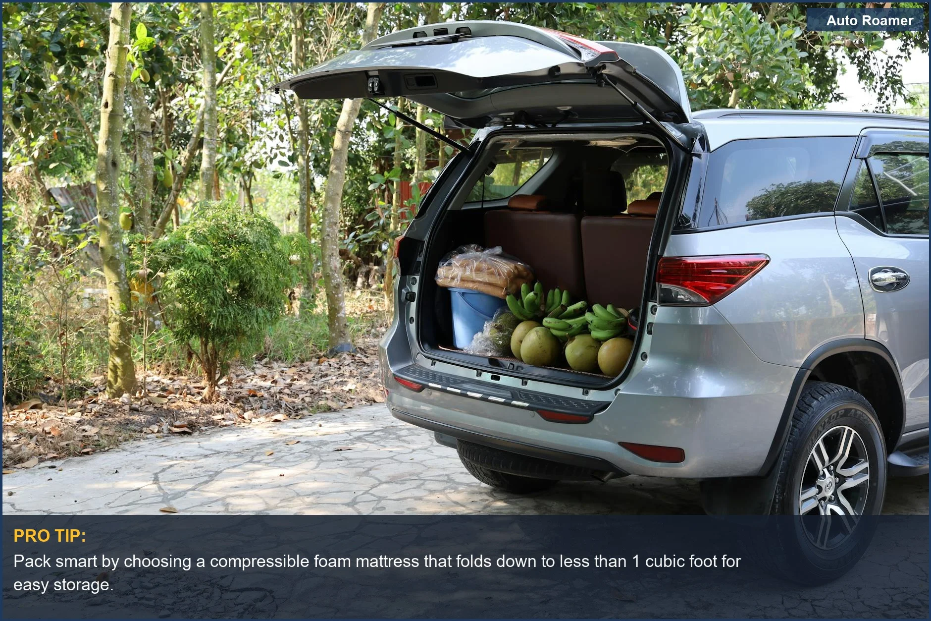 SUV with open trunk displaying tropical fruits and bread in Vietnam, highlighting limited cargo space for foam mattress.