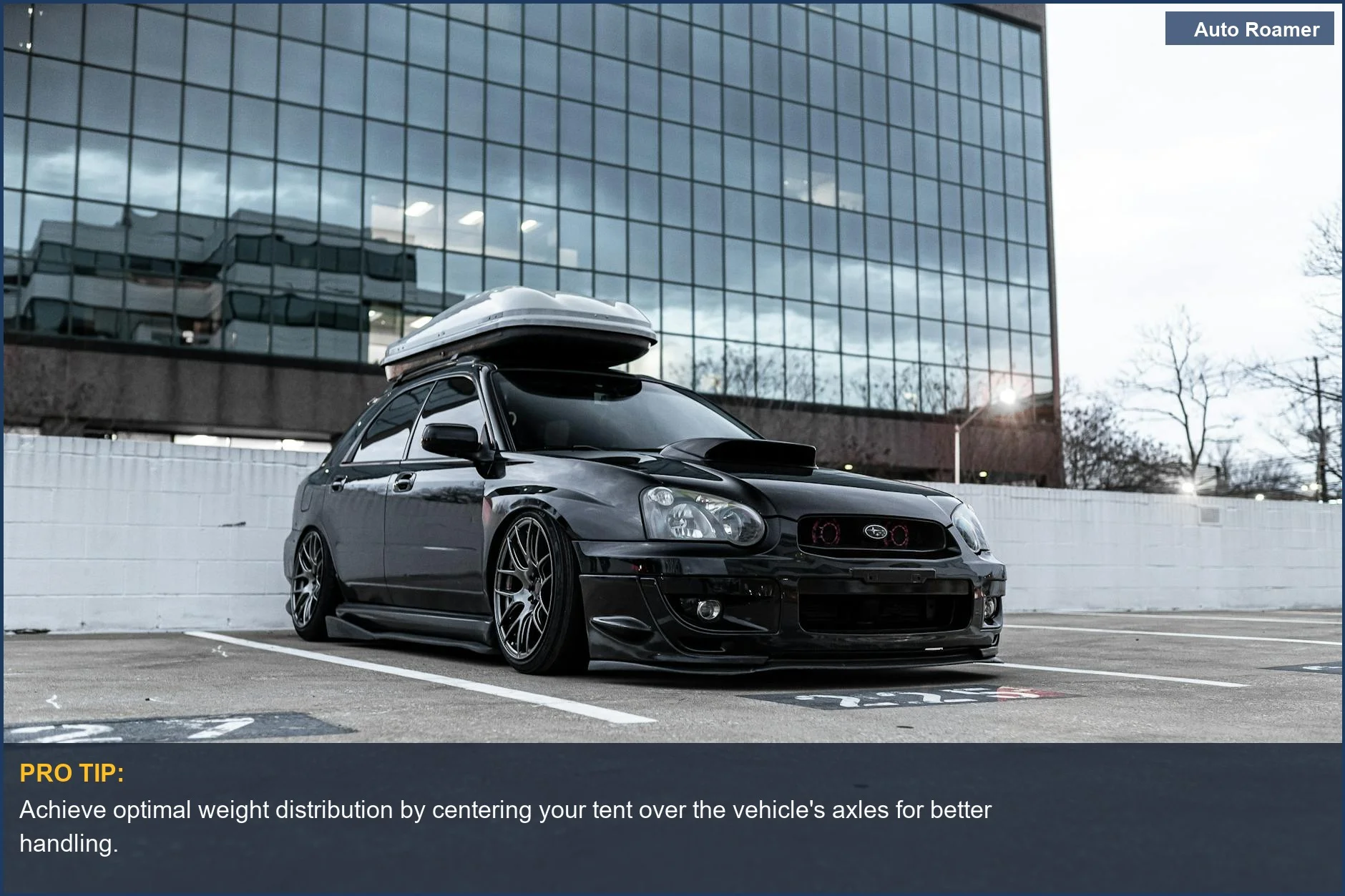 Sleek black car with luggage rack parked near modern building, ready for rooftop tent mounting.