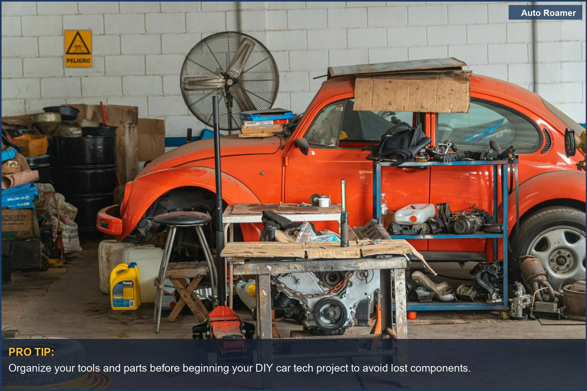 Classic red car in a cluttered garage, highlighting the complexity of DIY car tech projects.
