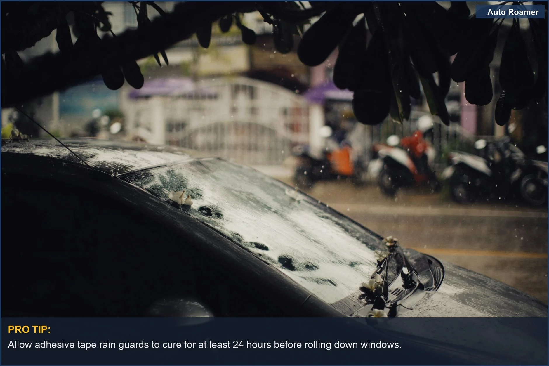 Easy car mods: Black car parked on a wet city street with raindrops, showcasing rain guards.