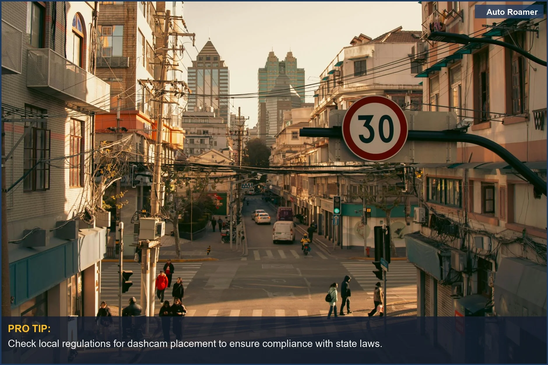 Busy city street intersection with vehicles and pedestrians; dashcam legality varies by state.