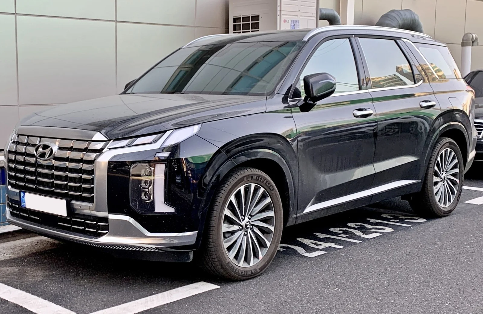 Black Hyundai Palisade Calligraphy, current facelift generation, front three-quarter view showing the parametric grille and LED lights.