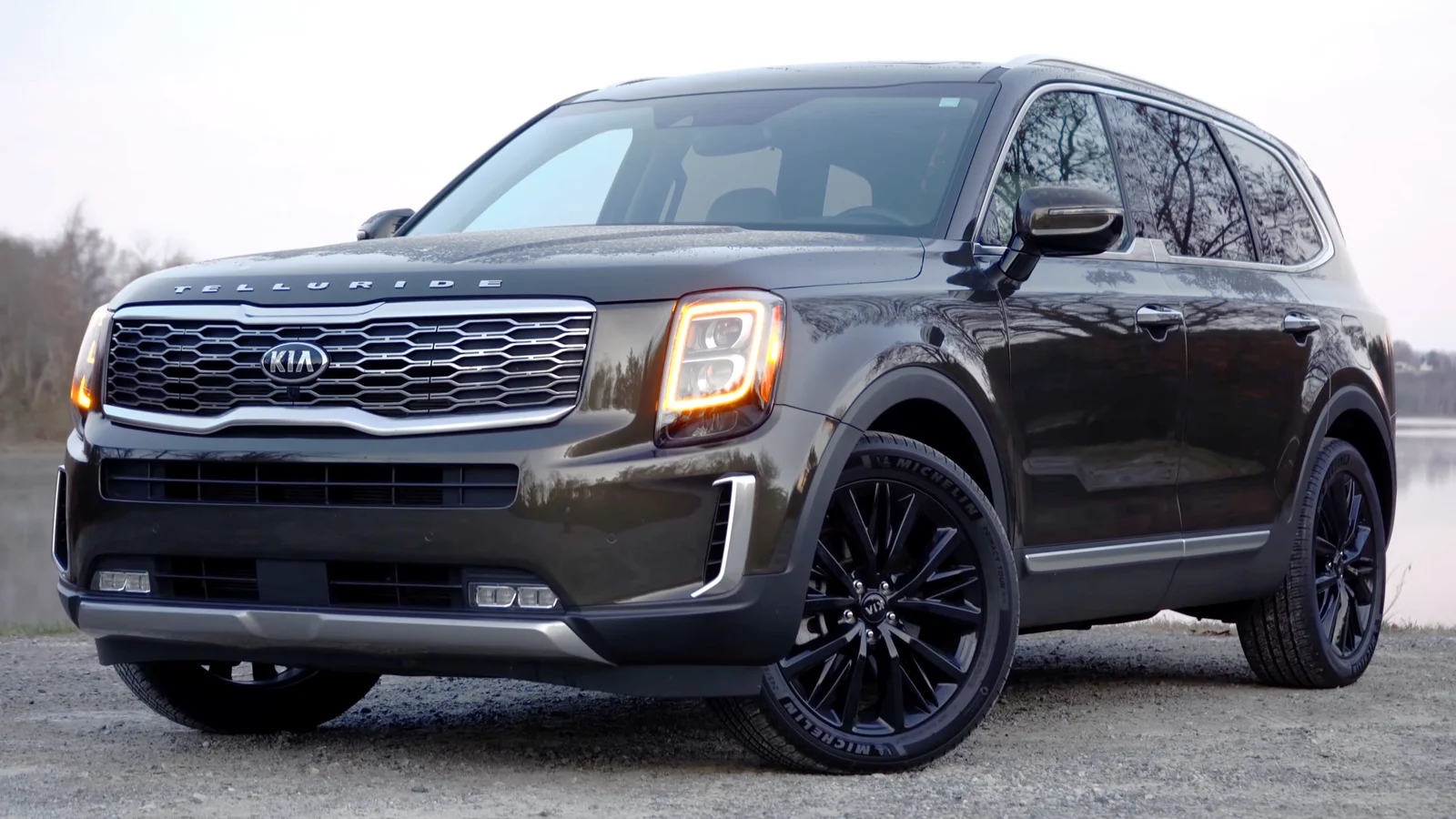 Brown Kia Telluride SX, first-generation pre-facelift, front three-quarter view with black alloy wheels.