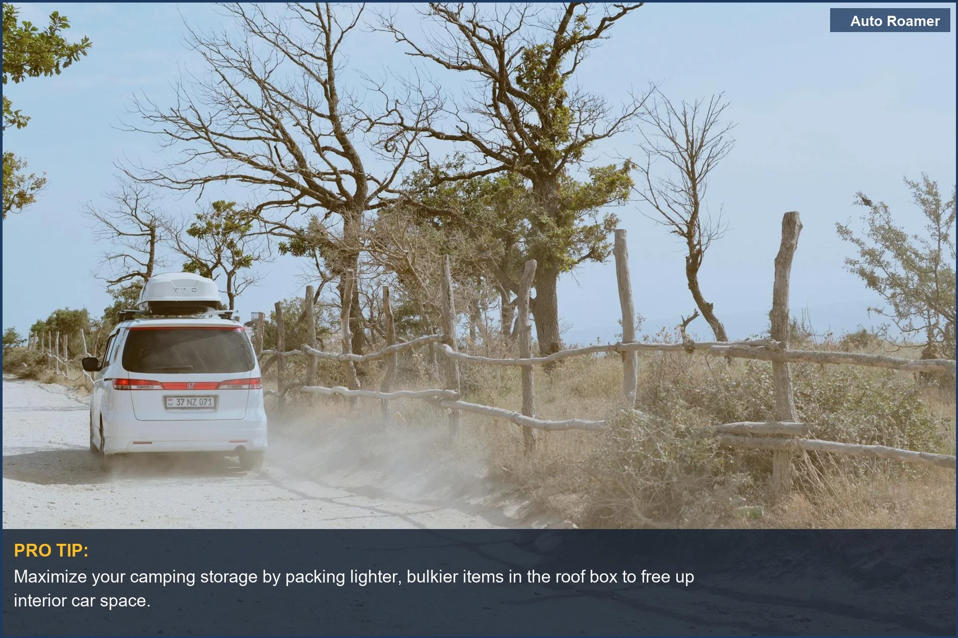 White SUV with roof box drives on a sunny dirt road through trees, a great camping storage solution.