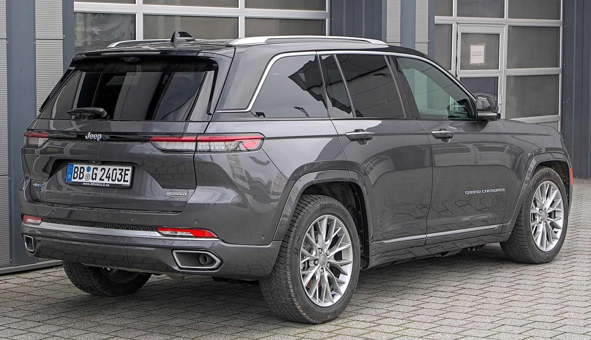 A gray two-row Jeep Grand Cherokee (WL generation), rear three-quarter view of the SUV whose folded cargo length this sleeping guide measures.