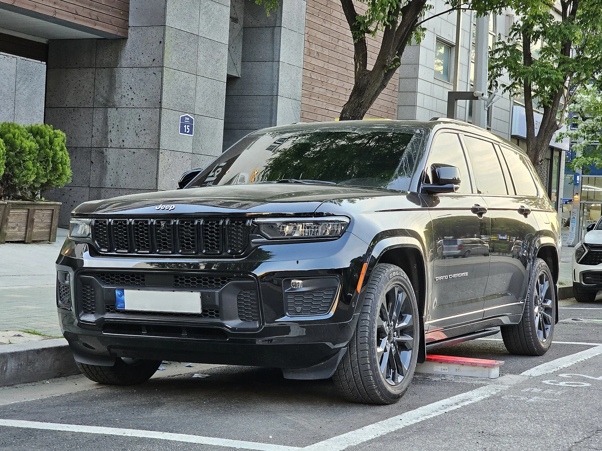 A diamond-black Jeep Grand Cherokee (WL generation) parked outdoors, the premium midsize SUV whose cargo dimensions this sleeping guide measures.