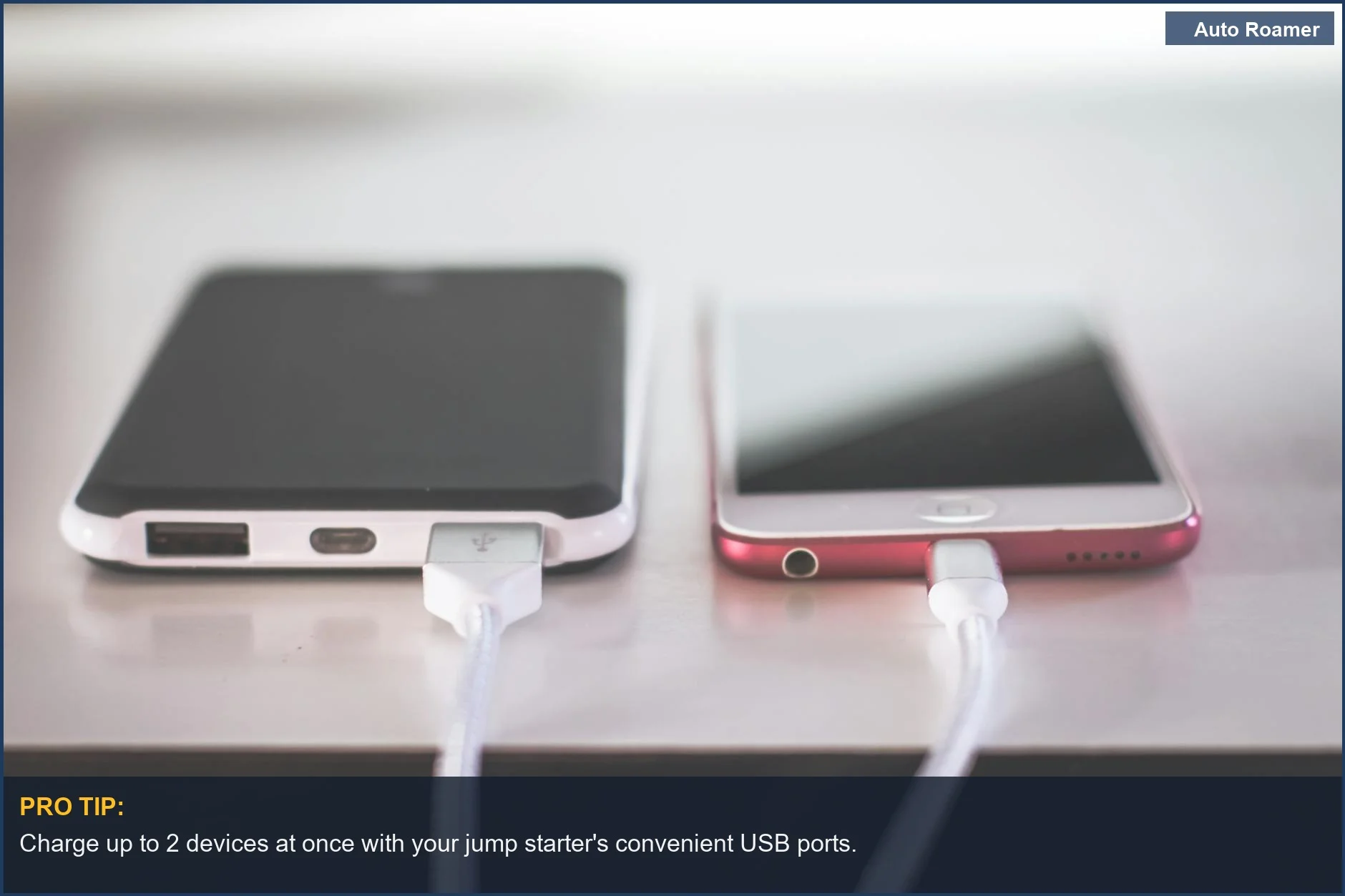 Two smartphones charging simultaneously using a portable jump starter's USB ports.