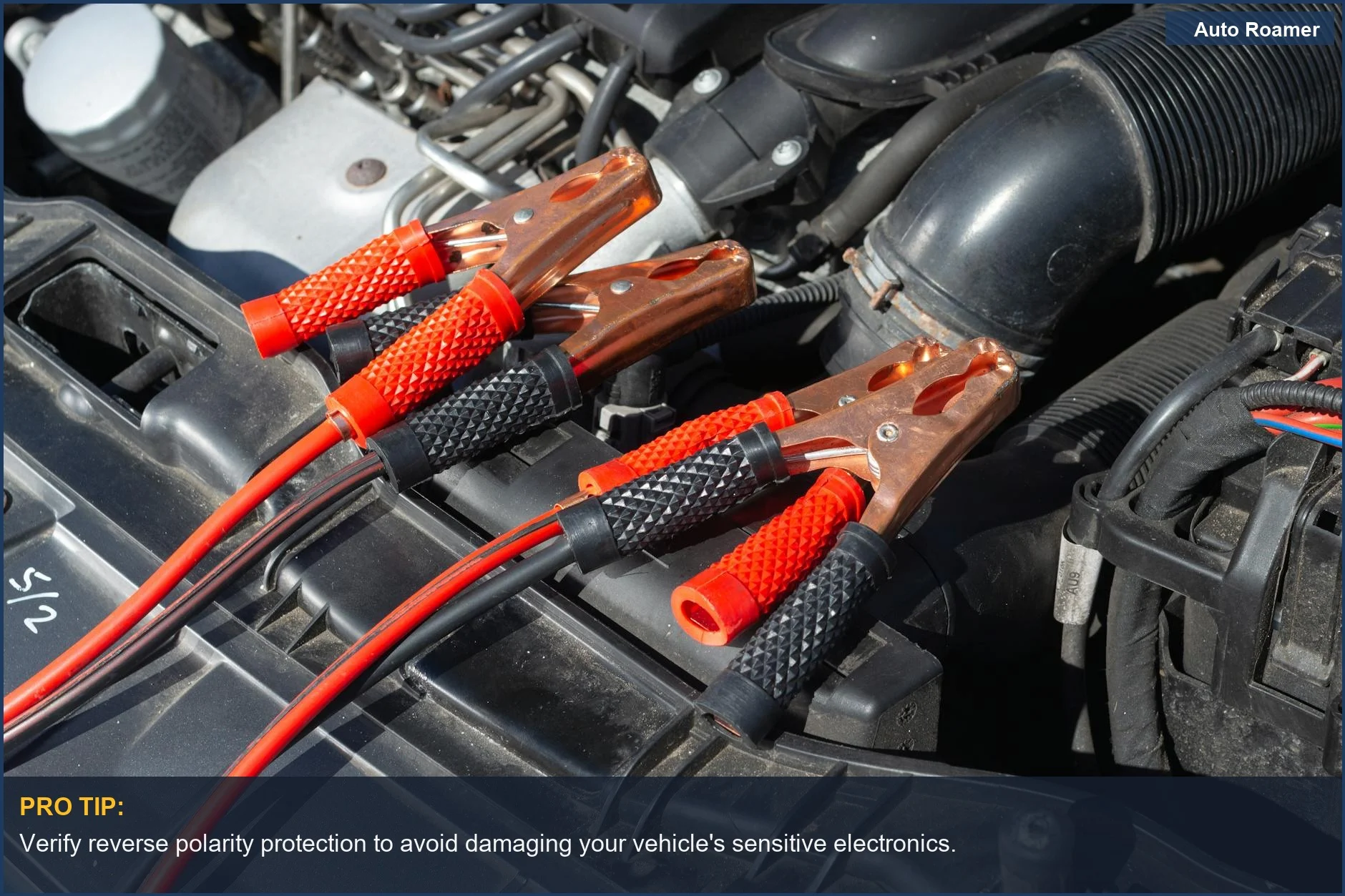 Close-up of a car engine with jump starter cables attached, highlighting jump starter safety mechanics.