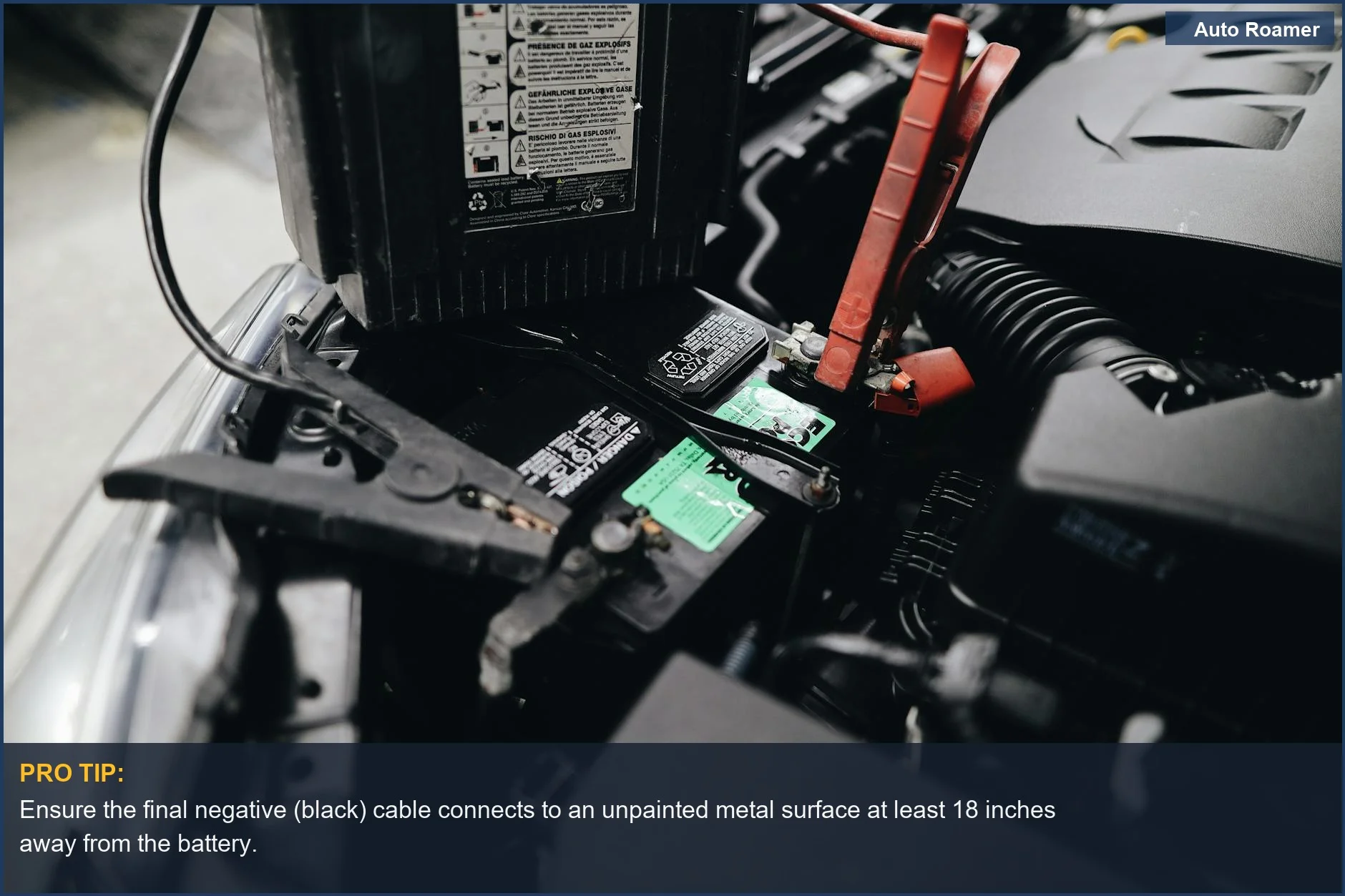 Close-up of a car battery terminal during a jump start, highlighting jumper cable safety connections.