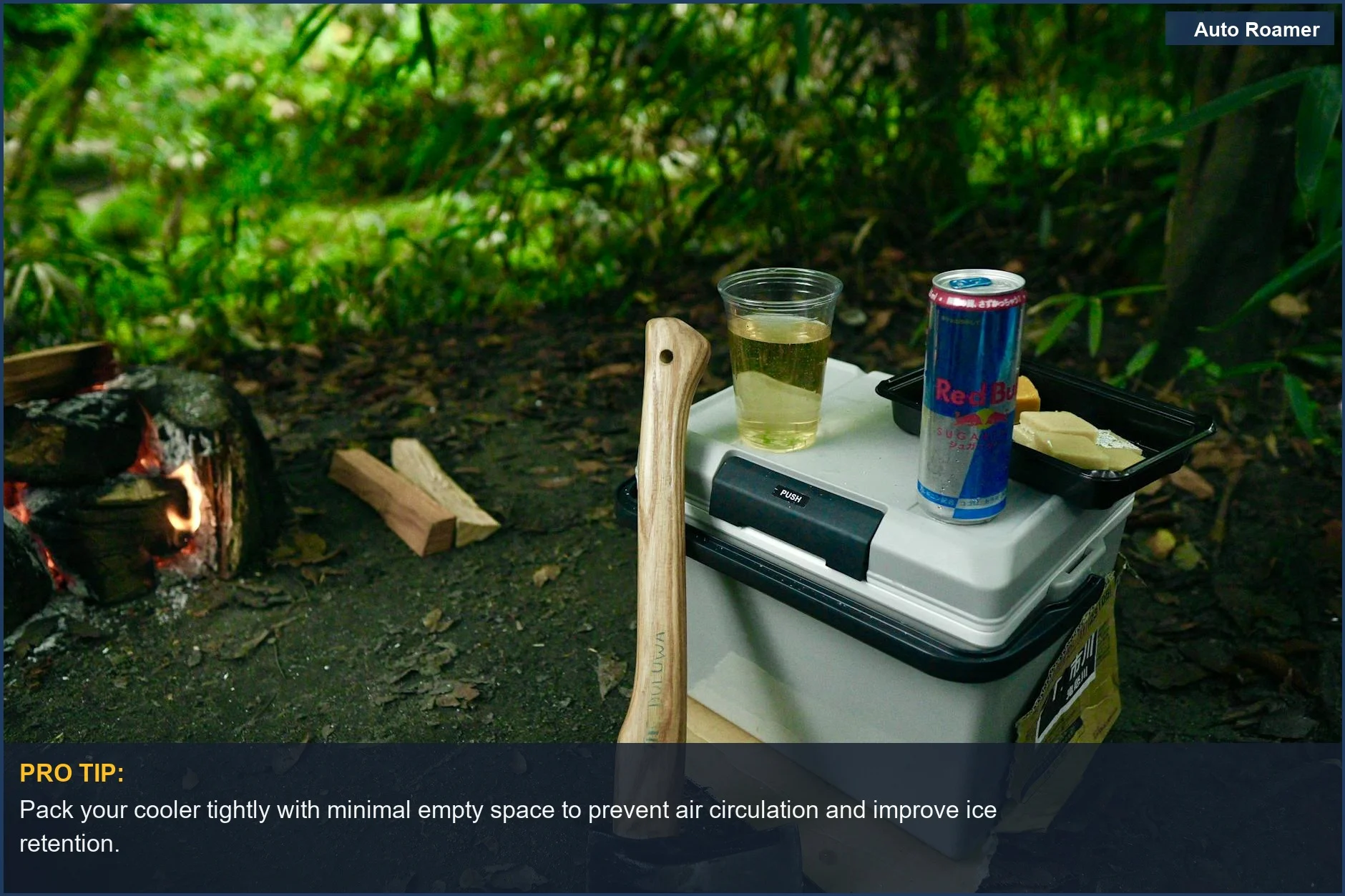 Serene campsite setup with axe, fire pit, cooler, and energy drink, highlighting essential car camping gear.