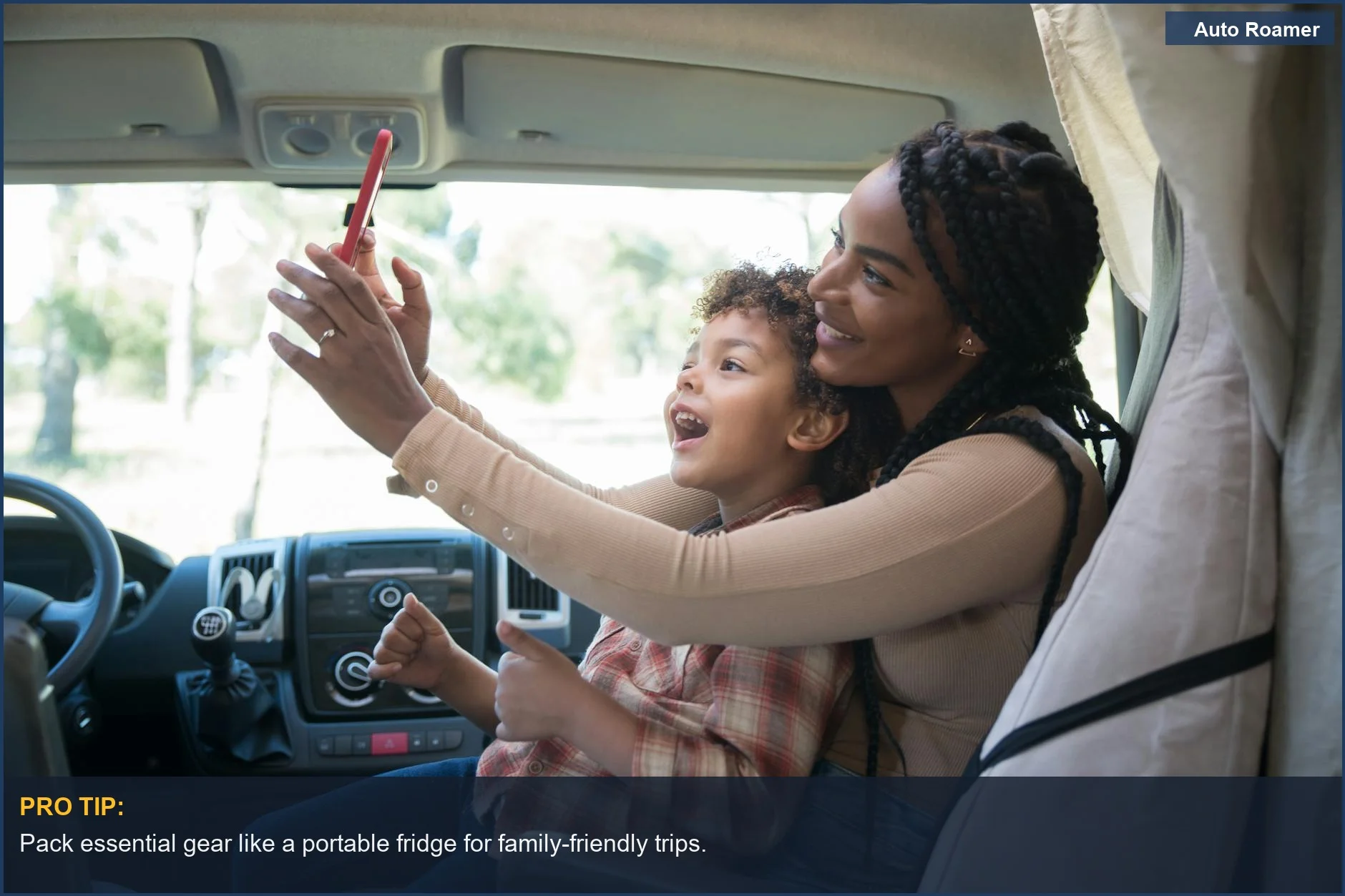 Mother and son taking a selfie inside the Kia Carnival campervan.