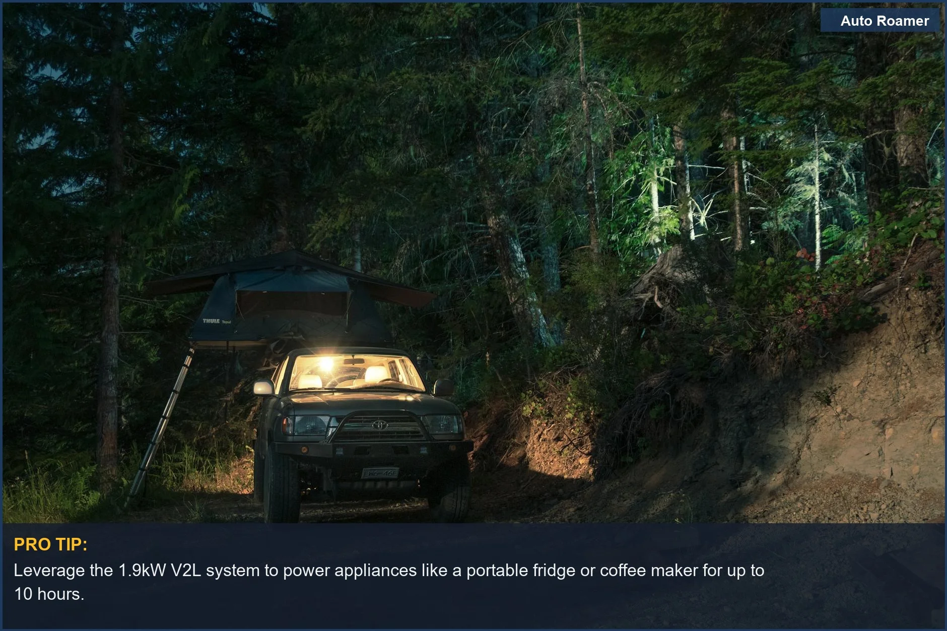 Kia EV9 parked at night in a dimly lit forest campsite, ready for V2L power.