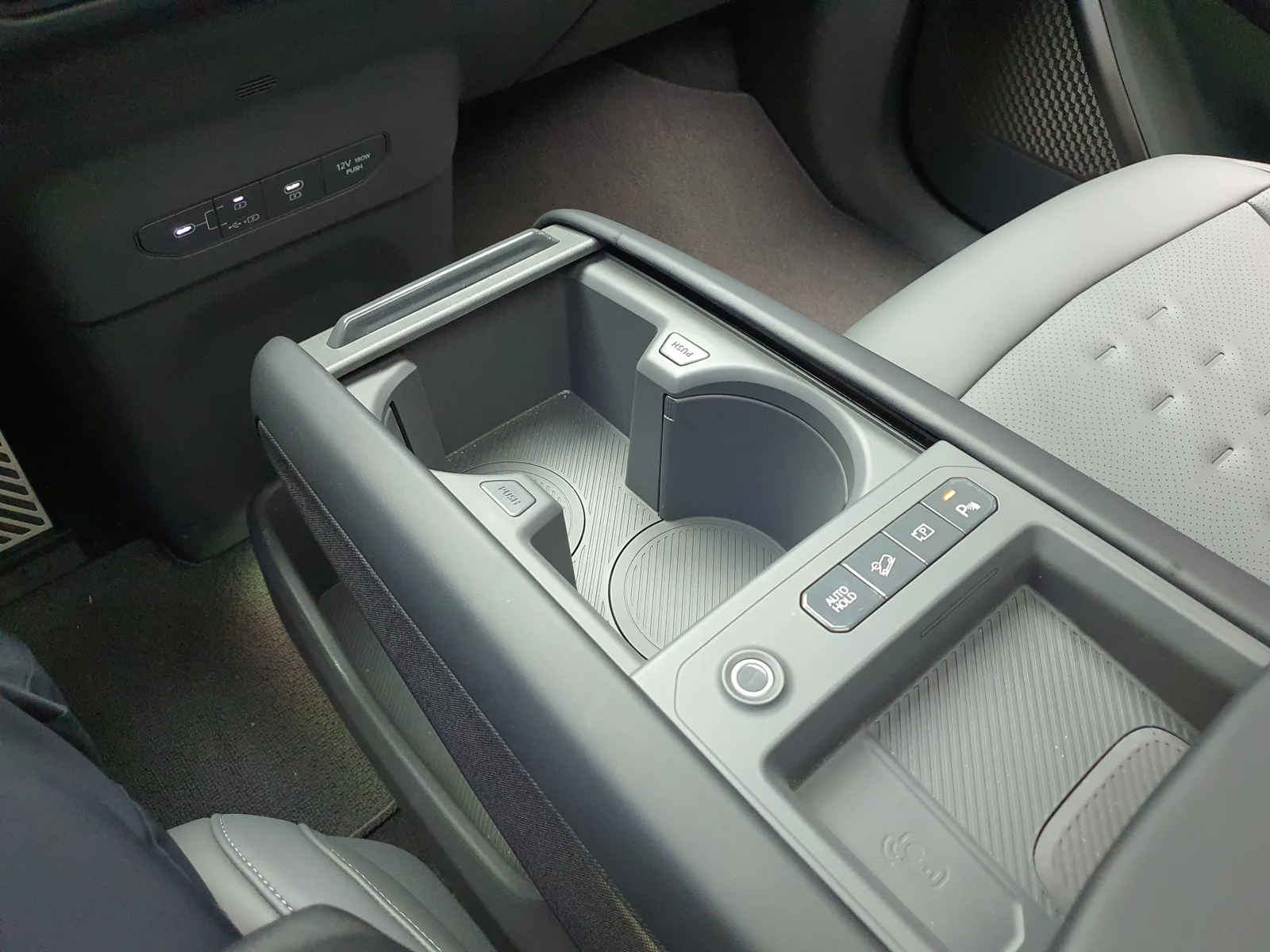 The center console of a Kia EV9 with its storage and ports, part of the EV9 cargo-and-camp-power layout this sleeping guide walks through