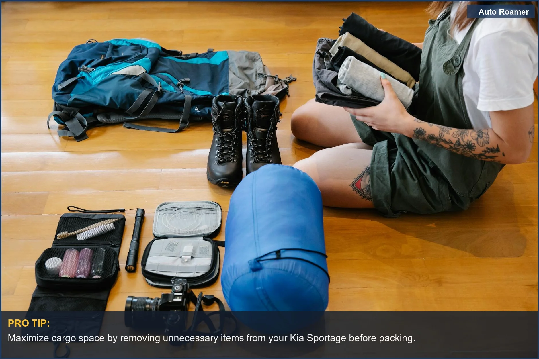 Woman organizing camping gear and clothes indoors, preparing her Kia Sportage for an outdoor journey.