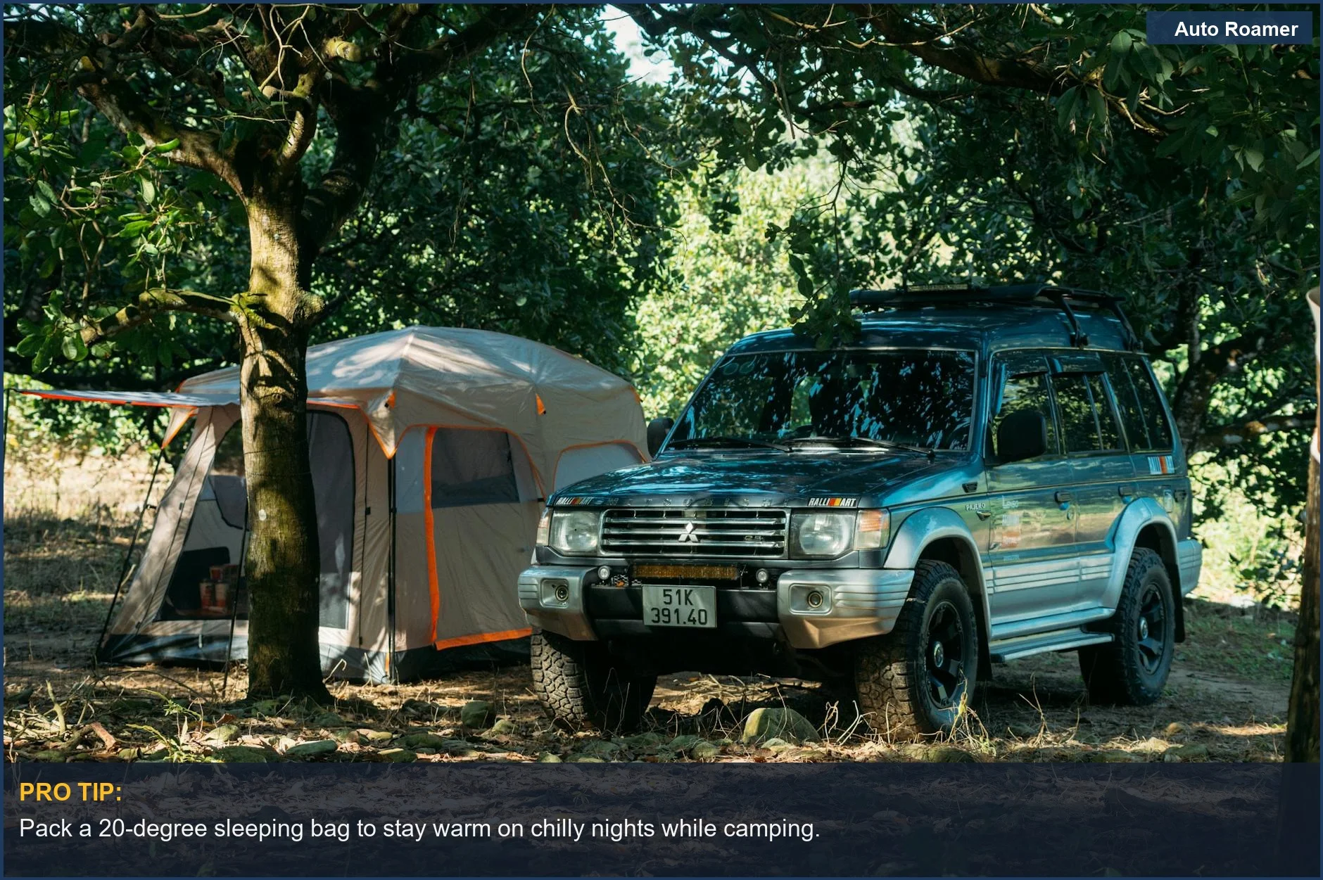 Kia Telluride parked next to a spacious tent in a lush forest setting.