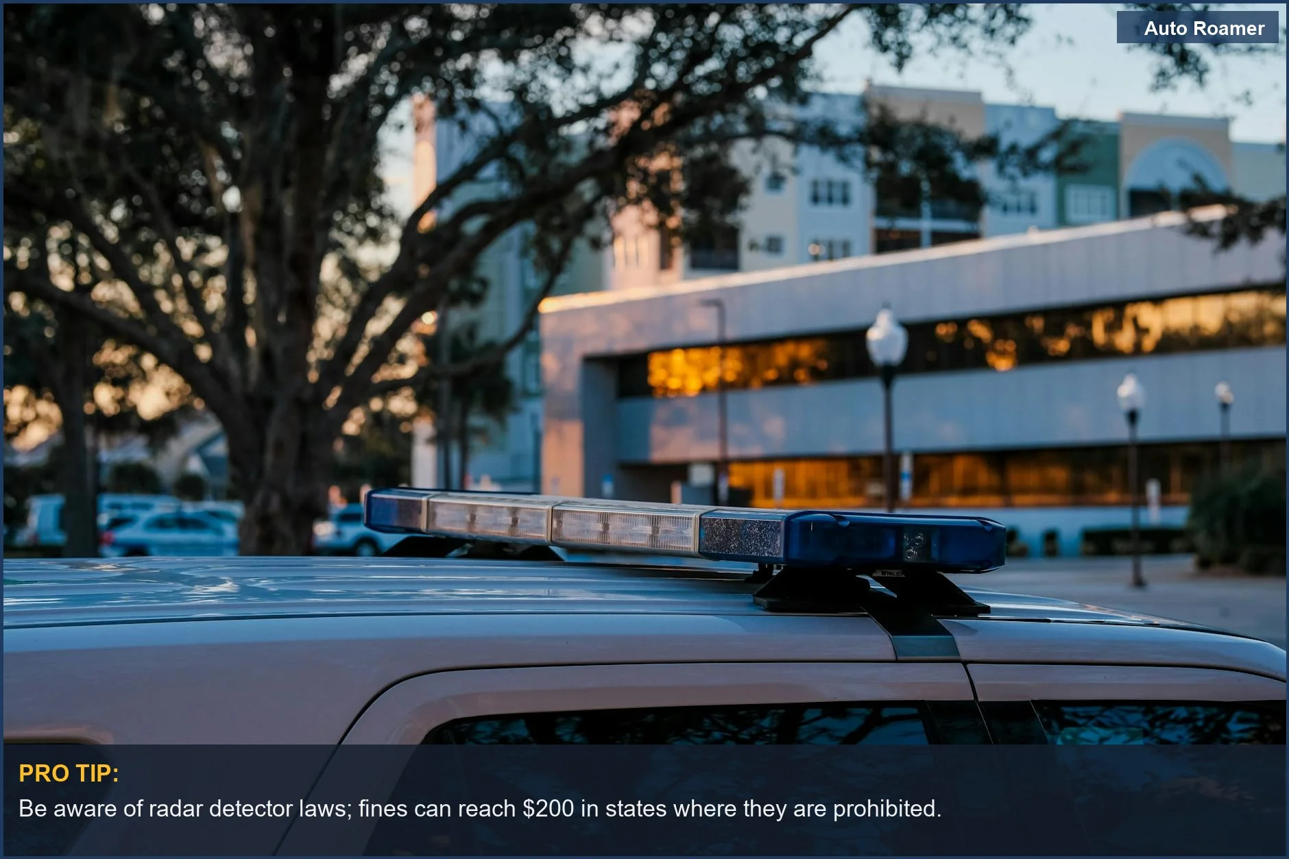 Police vehicle with emergency lights at dusk, highlighting the enforcement aspect of radar detector laws.