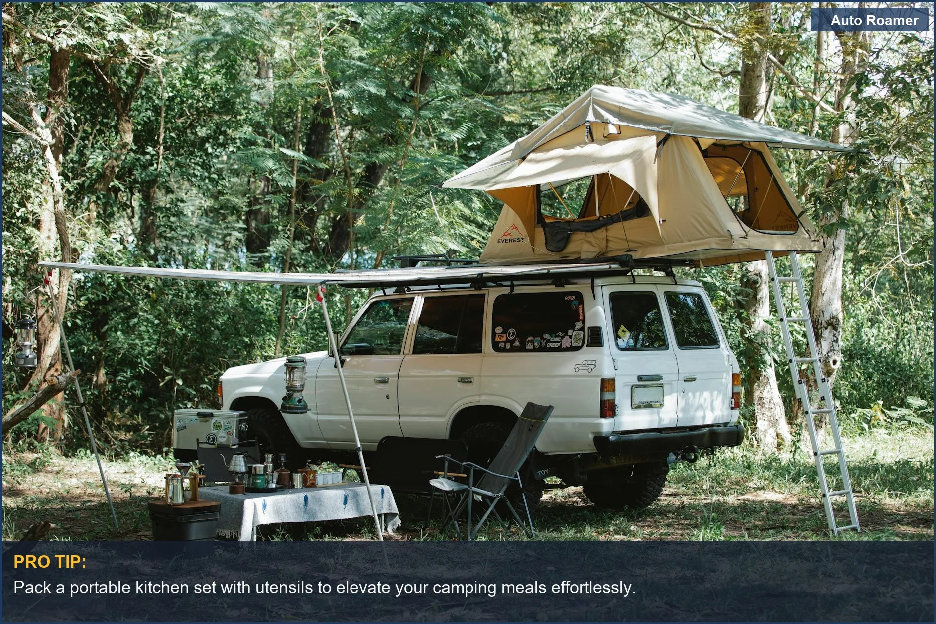 Off-road Mazda 3 with a rooftop tent set up for a picnic in a green forest.