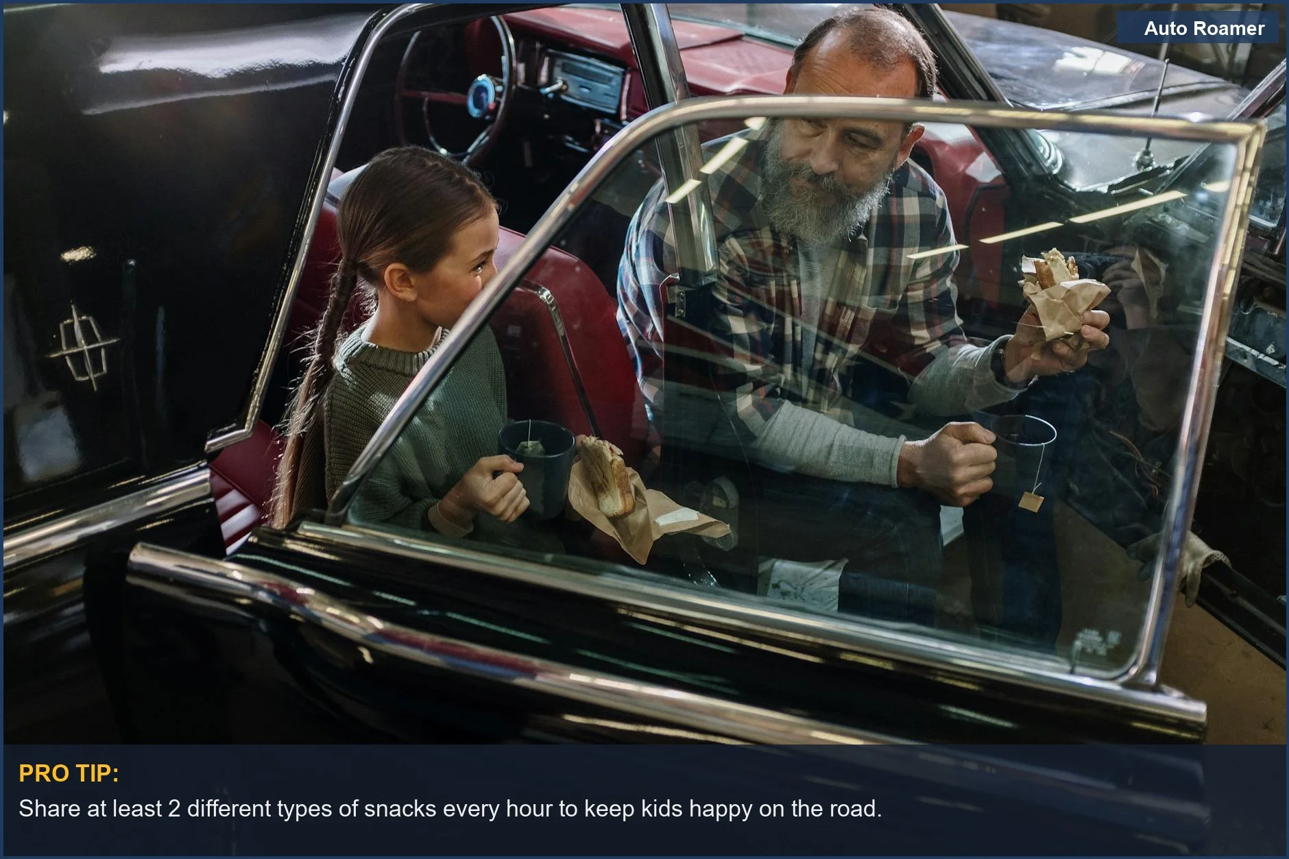 Father and daughter happily share road trip snacks inside a vintage car.
