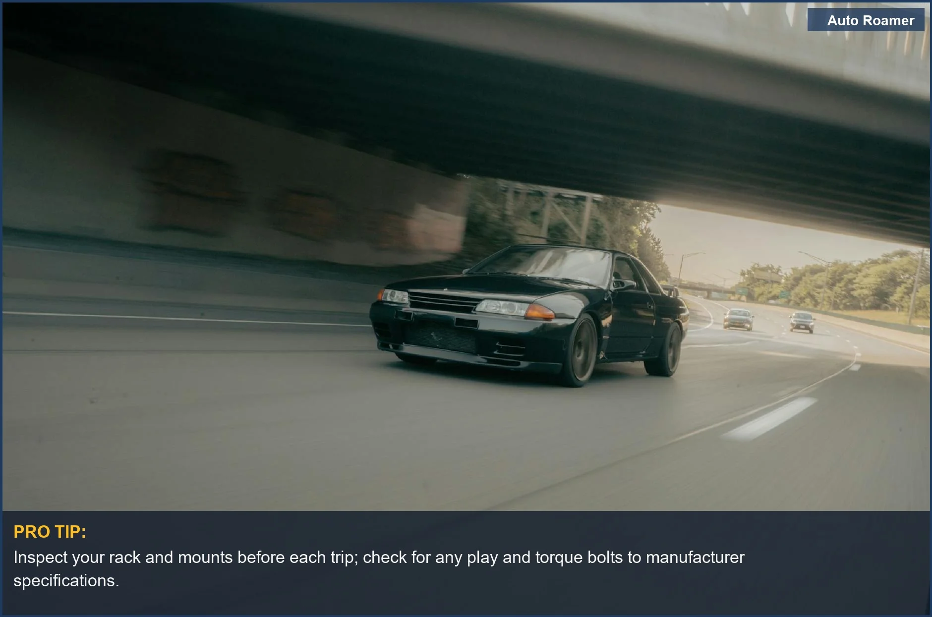 Black sports car speeding under an overpass on a multi-lane highway, emphasizing rack inspection for roof cargo safety.