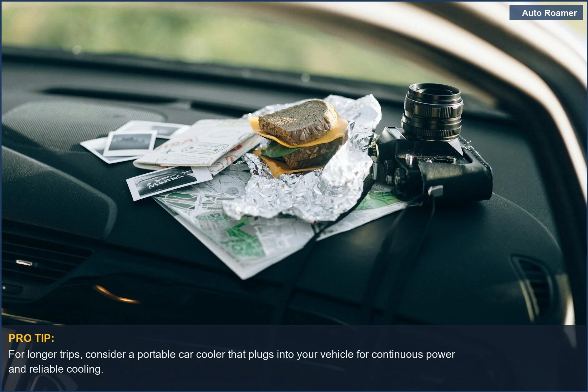 Car dashboard with a sandwich and camera, highlighting road trip cooling options and travel essentials.