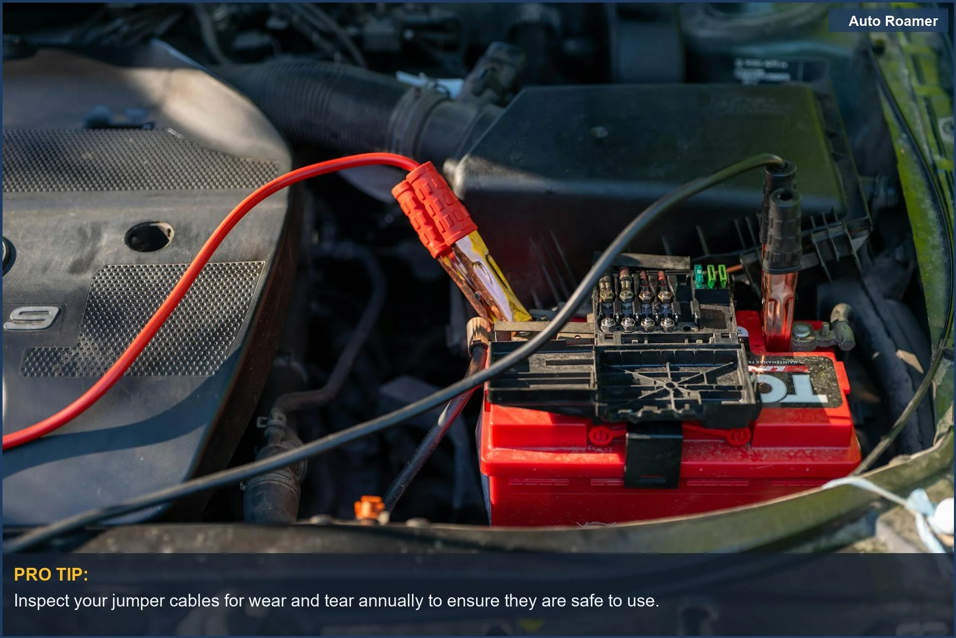 Close-up of car battery terminals with attached jumper cables, a common sight when needing a jump start.