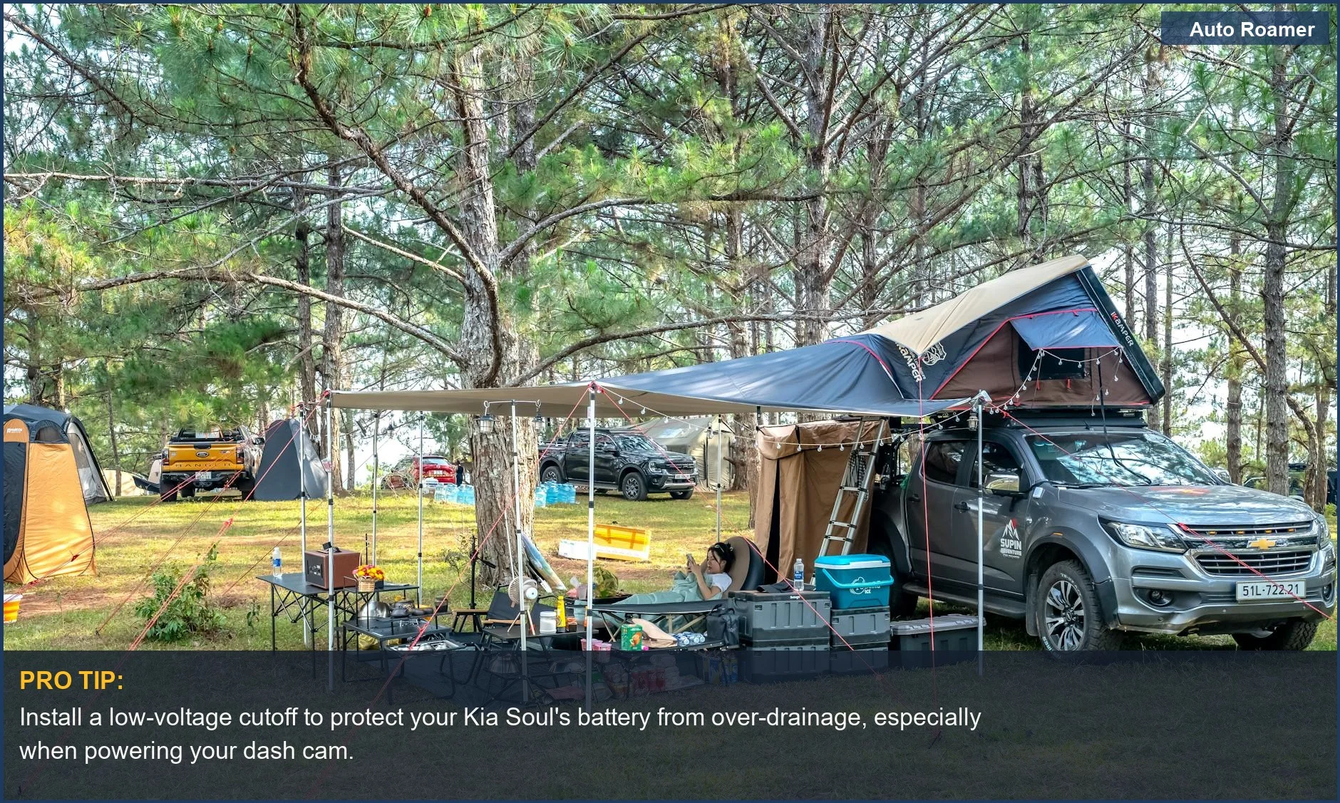 Kia Soul camping with rooftop tent and dash cam power options in wooded area.