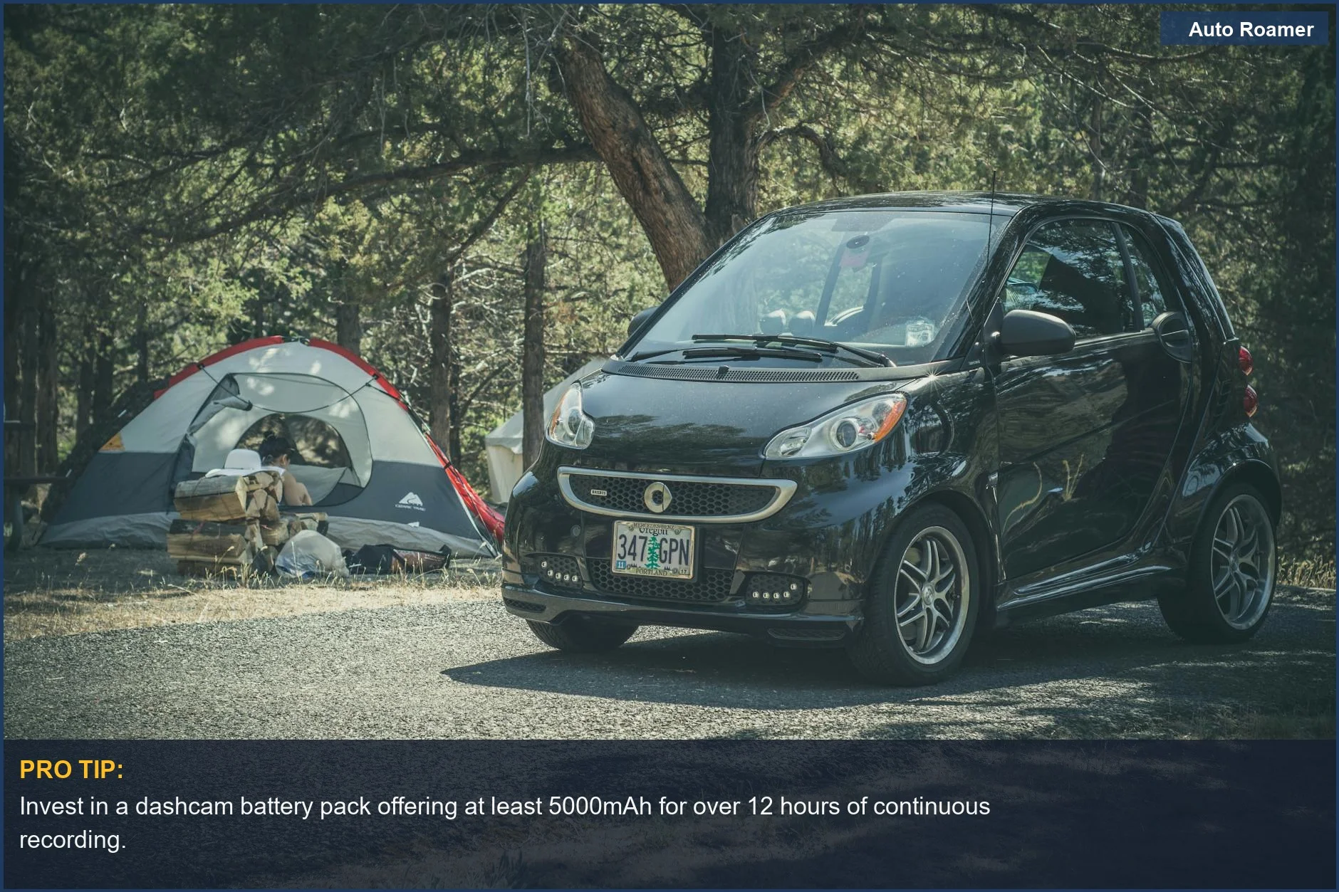 Smart car parked near a tent at a wooded campsite, ideal for overlanding dashcam battery solutions.