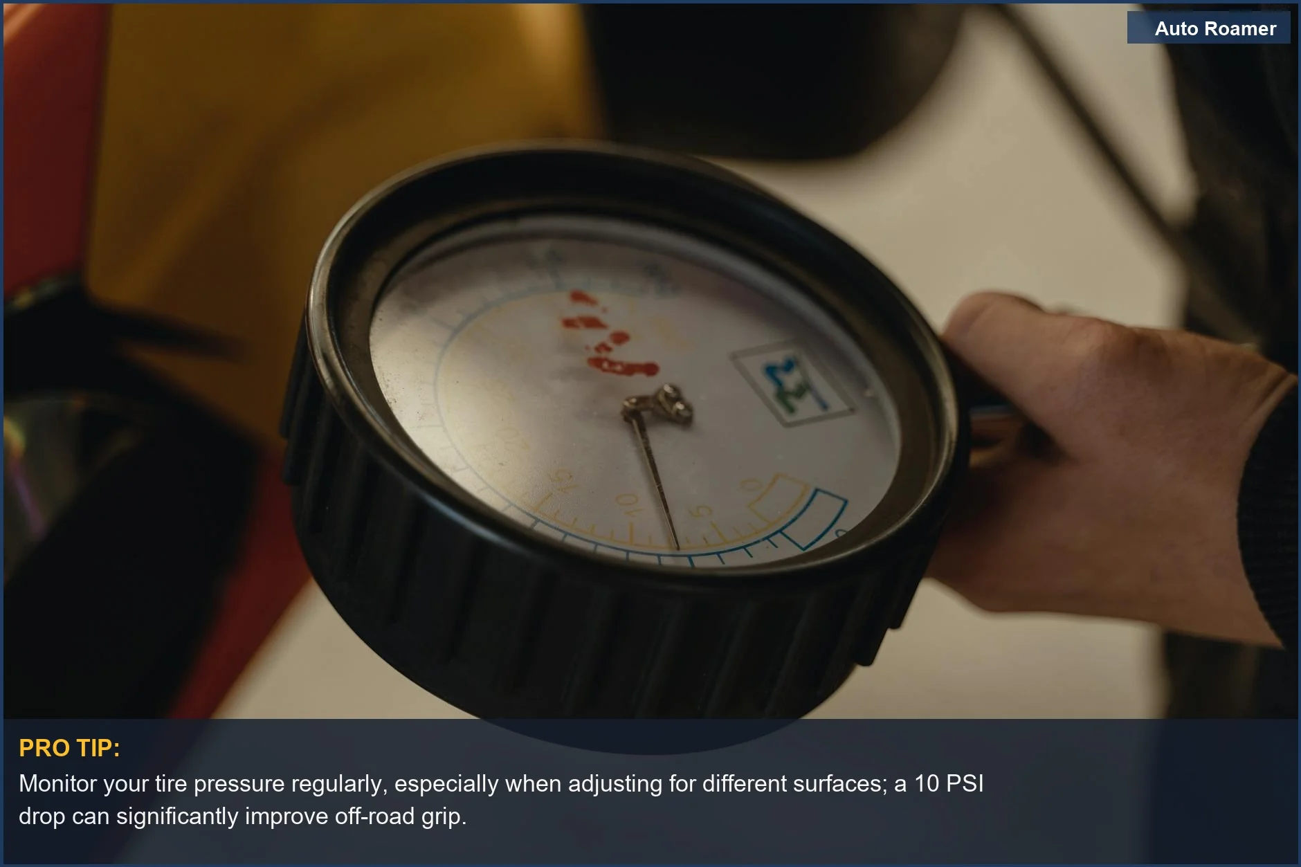 Primer plano de una mano sosteniendo un manómetro de neumáticos, esencial para la preparación del vehículo en carreteras remotas.