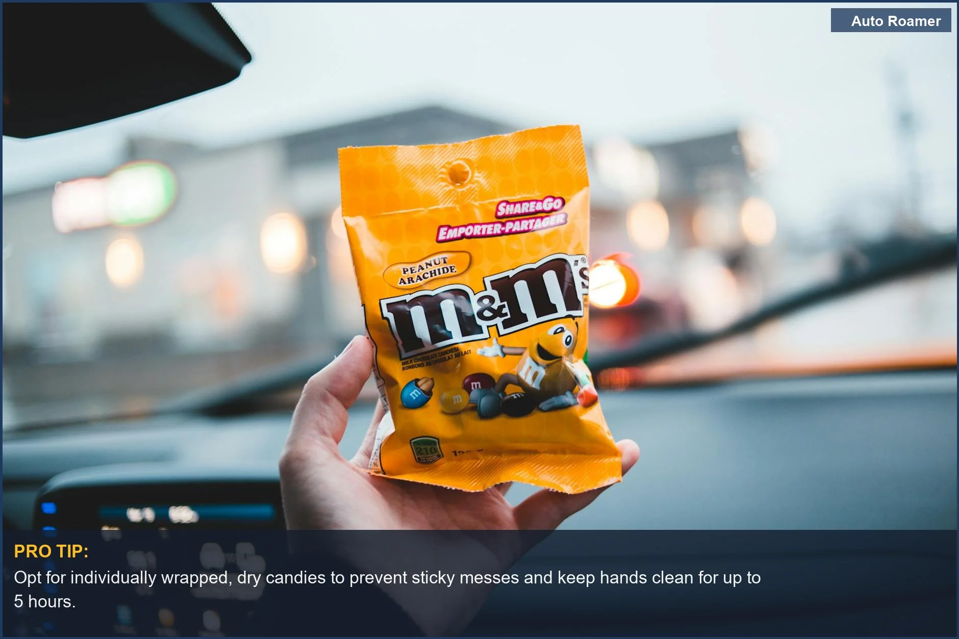Person holding colorful, dry road trip candies in a car, avoiding messy snacks.