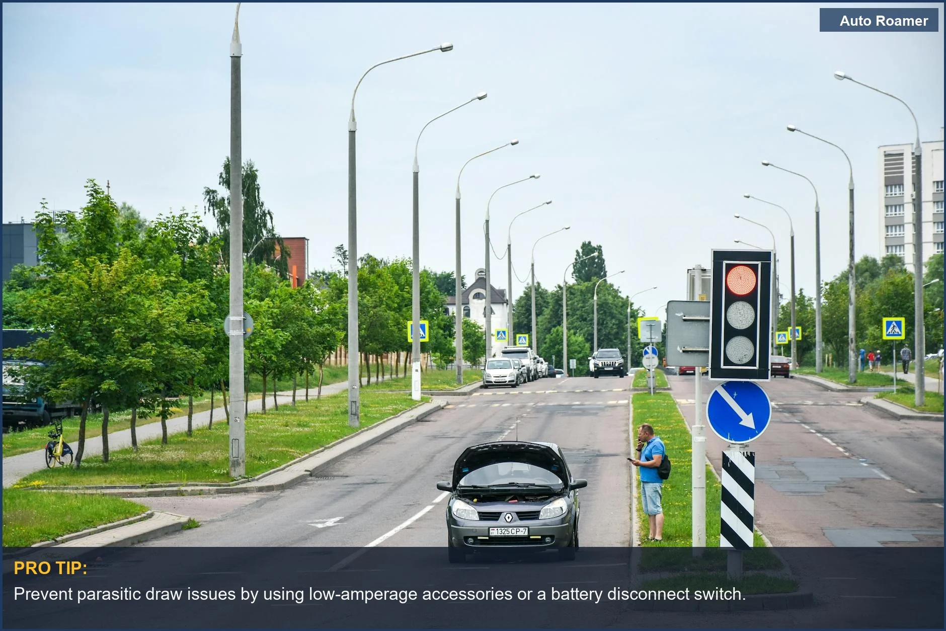 Man stranded with car on city street using phone, needing roadside assistance for accessory electrical issues.