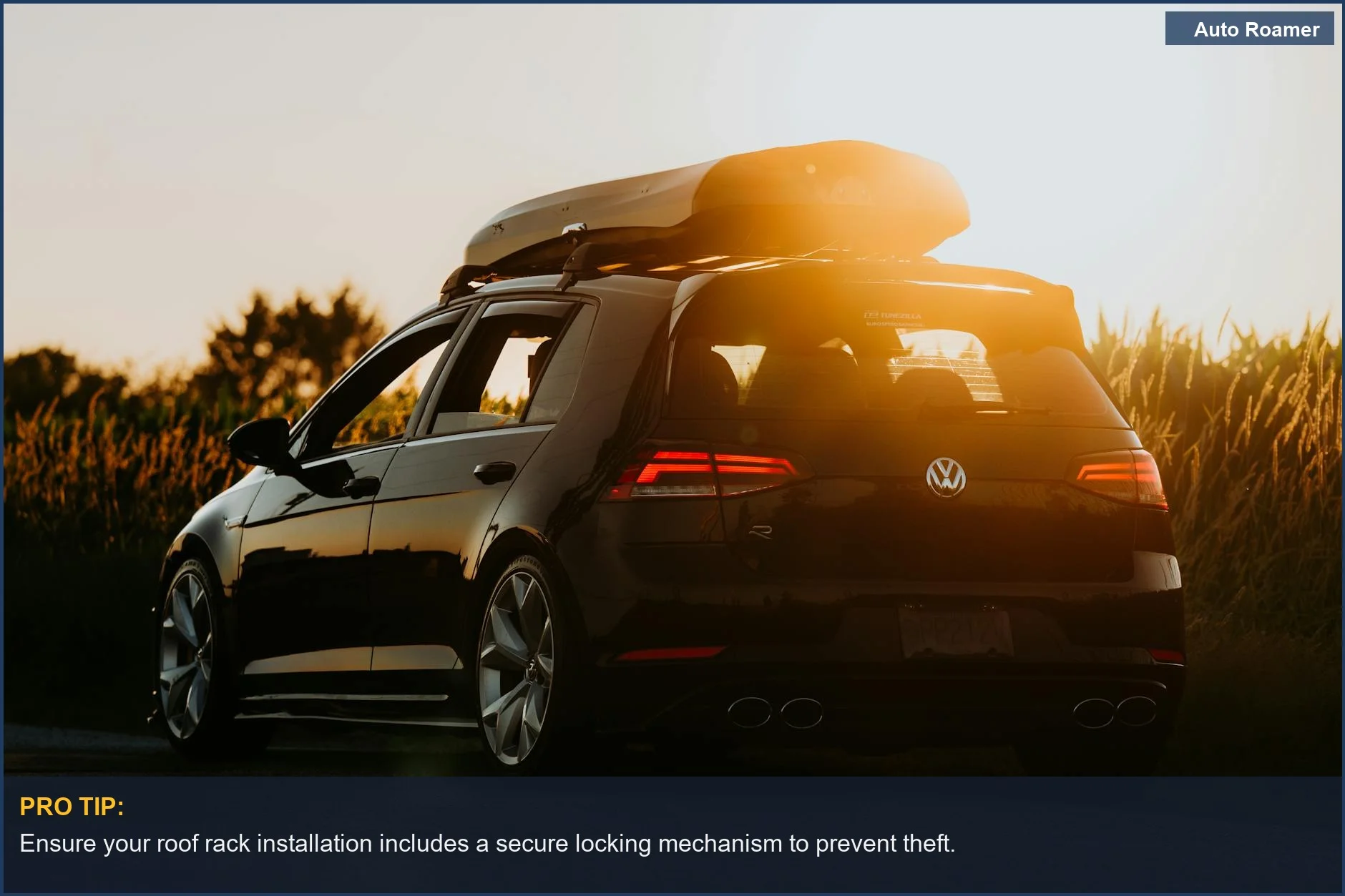Sleek black car with roof box parked on rural road at sunset, ideal for roof rack installation.