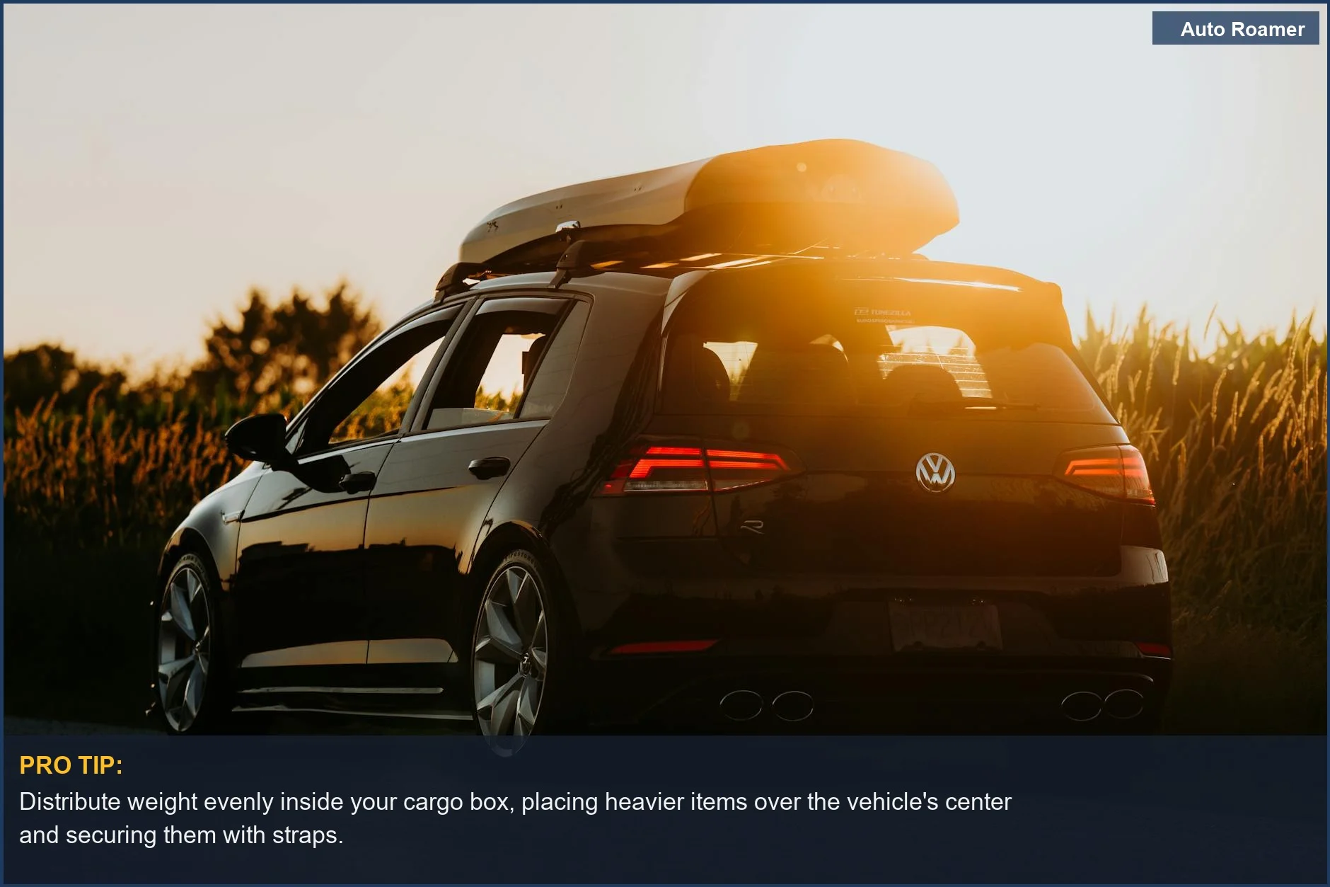 Sleek black car with roof box parked on a rural road at sunset, symbolizing safe rooftop cargo box travel.