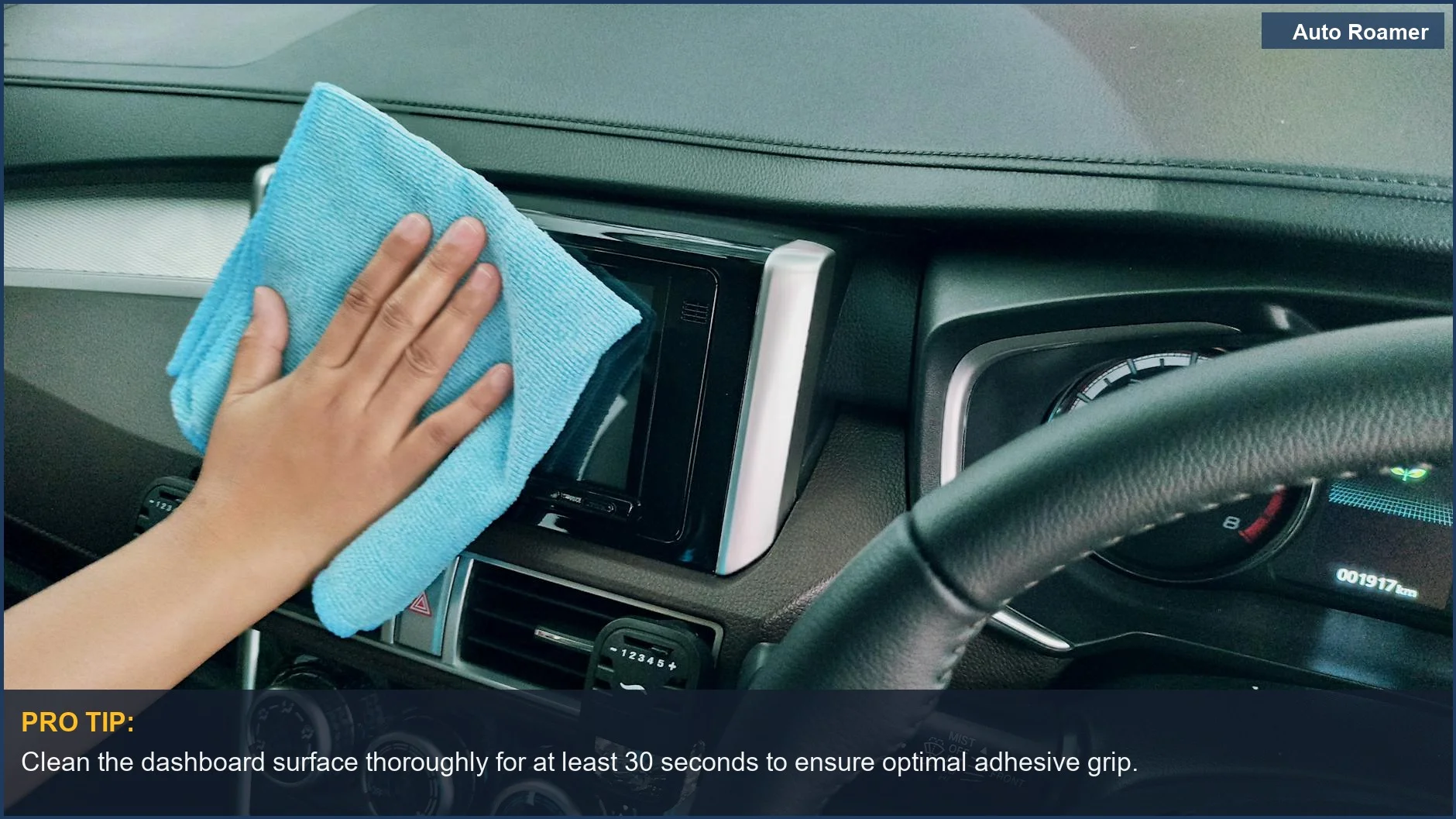 Hand cleaning car dashboard with microfiber cloth before installing a phone mount.