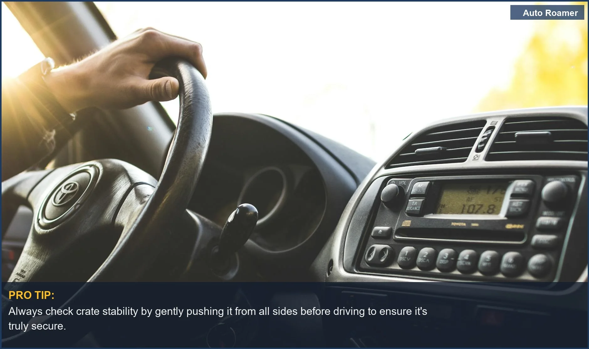 Hand on car steering wheel, illustrating the importance of securing your dog crate in the car for safe travel.