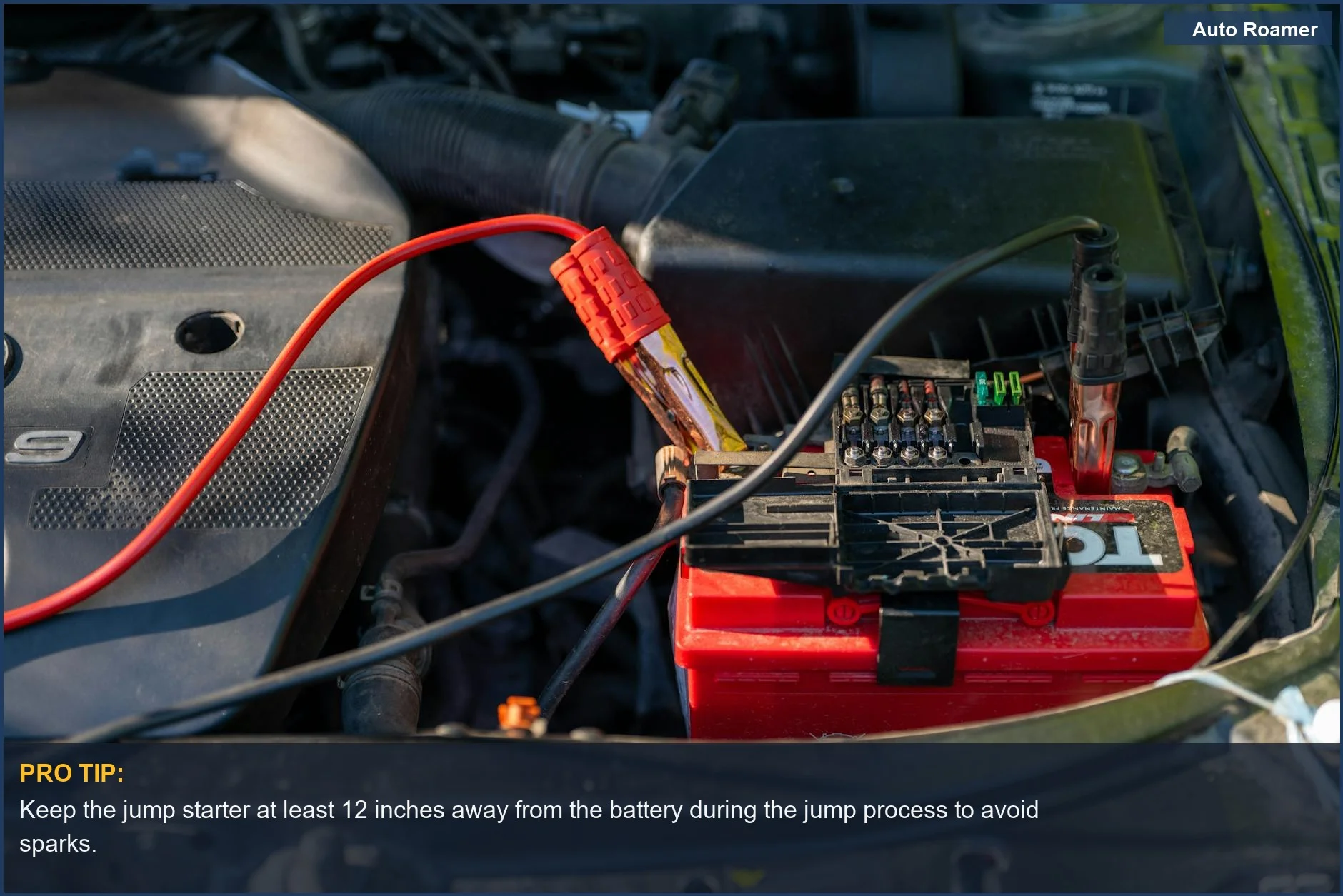 Detailed view of a car engine bay with a jump starter connected to the battery, essential for car emergency kits.